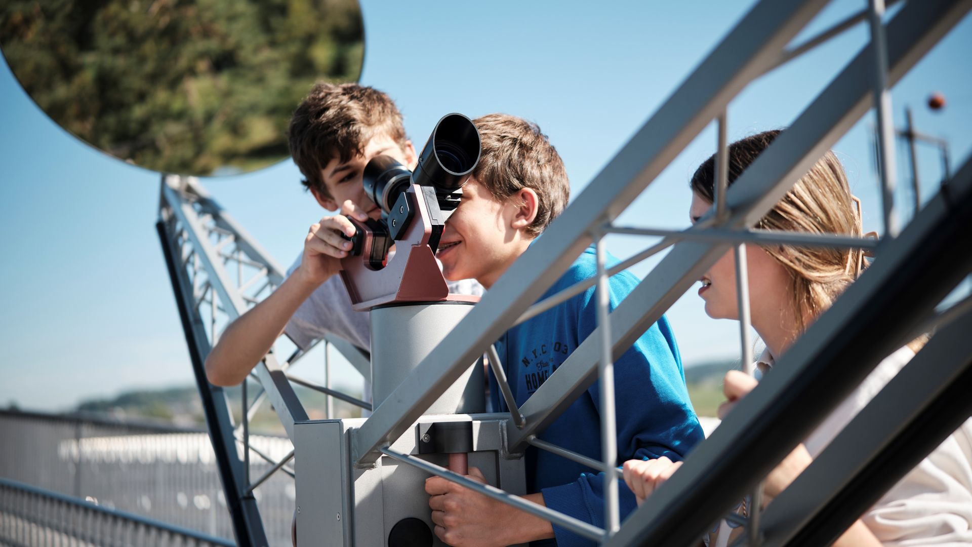 Students look through a small telescope in the outdoor area of the Technorama.