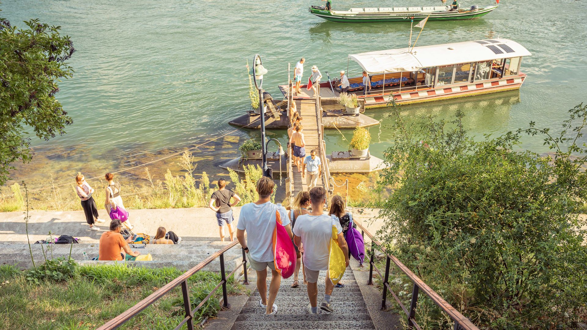 Eine bunt gemischte Gruppe von Personen steigt eine Treppe hinunter, unterhält sich und geniesst ihre Umgebung.