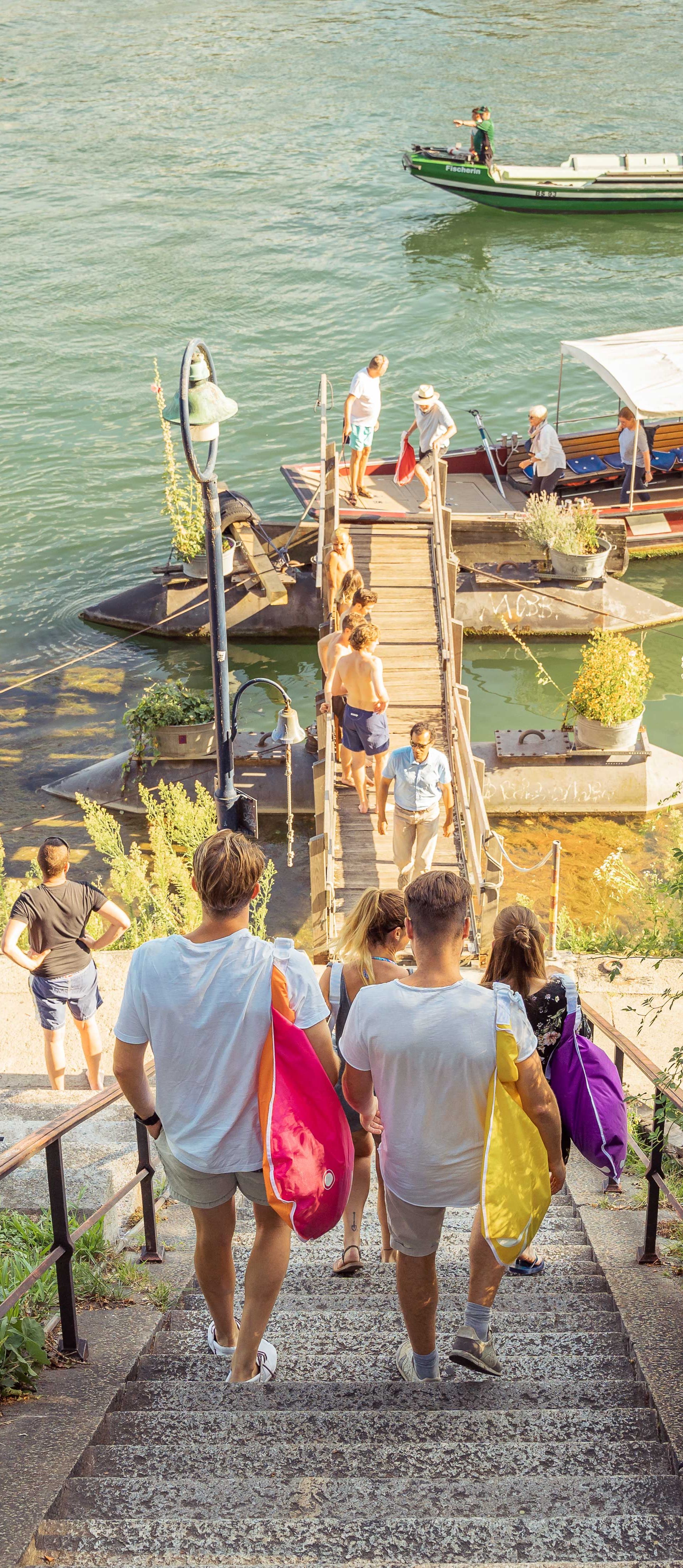 Eine bunt gemischte Gruppe von Personen steigt eine Treppe hinunter, unterhält sich und geniesst ihre Umgebung.