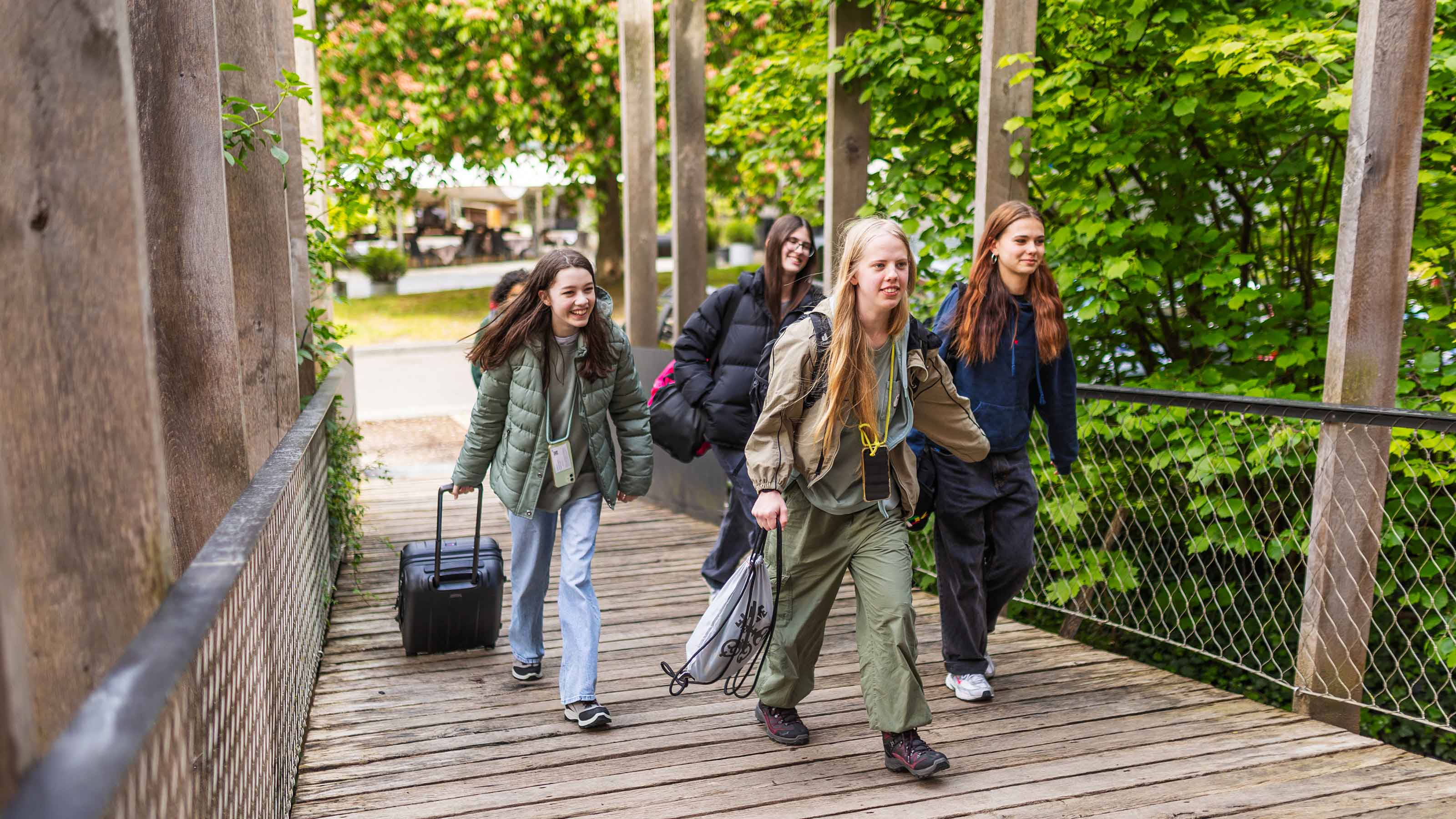 Quatre filles montent une rampe en bois jusqu'à l'entrée de l'auberge de jeunesse.