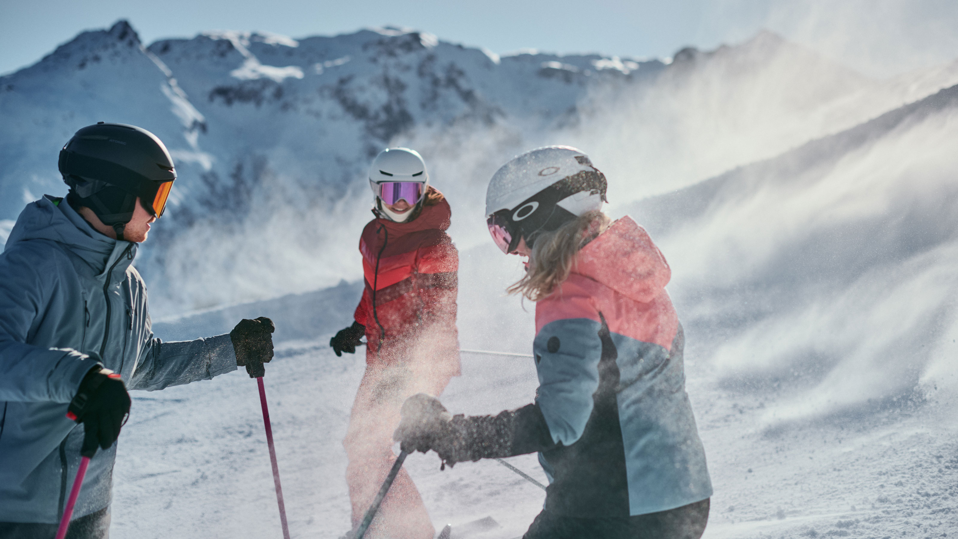 Tre individui in piedi su un pendio innevato, circondati da un paesaggio invernale.
