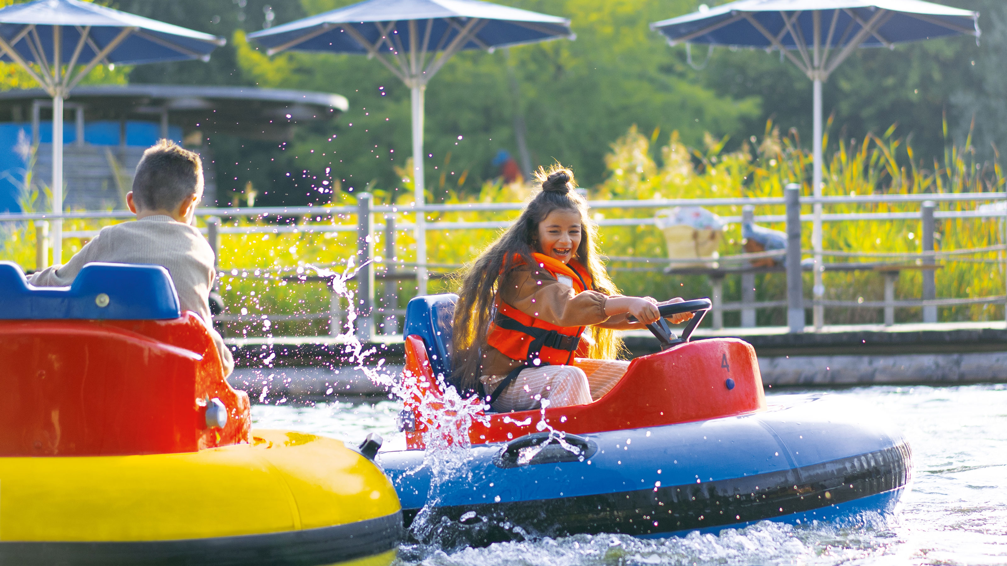 Deux enfants roulent dans des scooters des mers colorés au Ravensburger Spieleland.