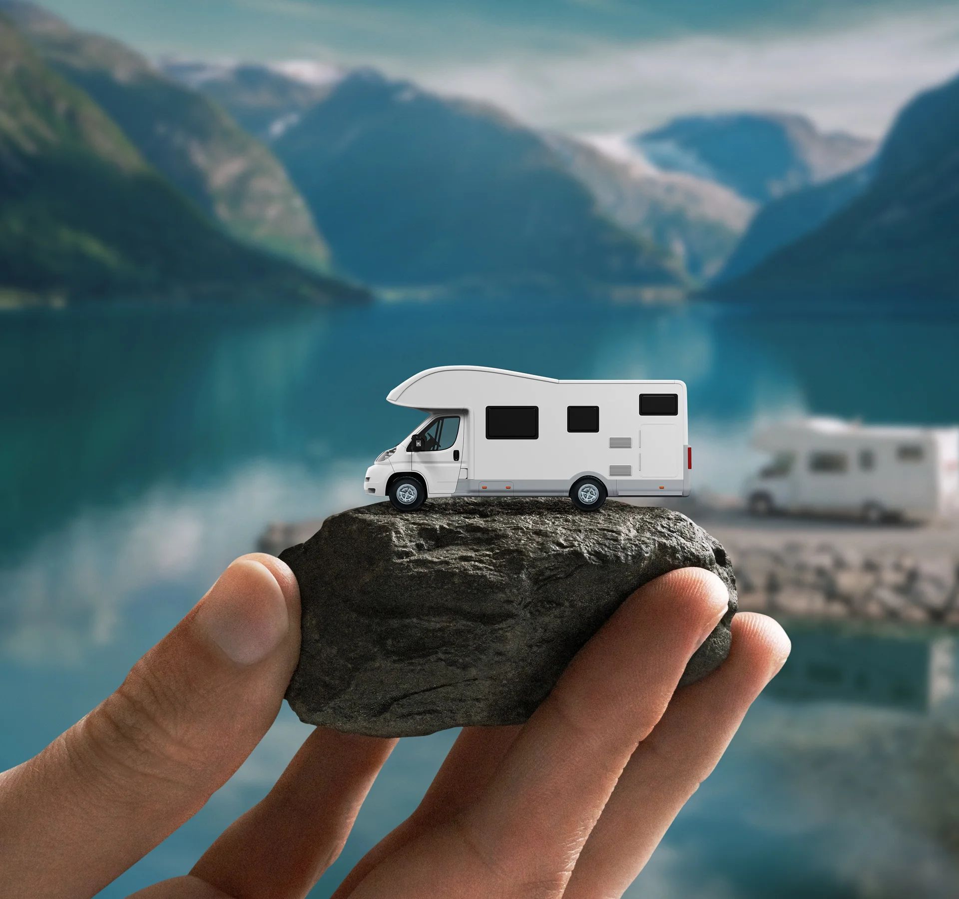 Eine Hand hält einen kleinen Wohnwagen als Symbol für mobiles Reisen am Suisse Caravan Salon.