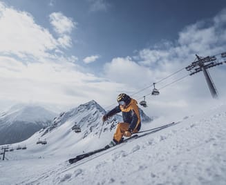 A skier descends a snowy slope.