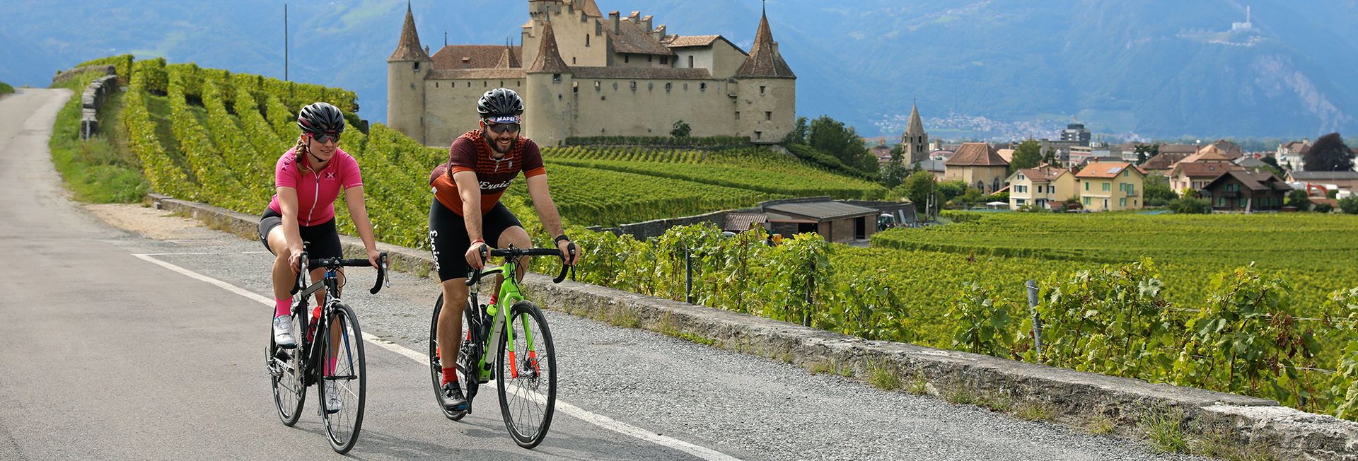 Cycliste sur route devant le Château d'Aigle