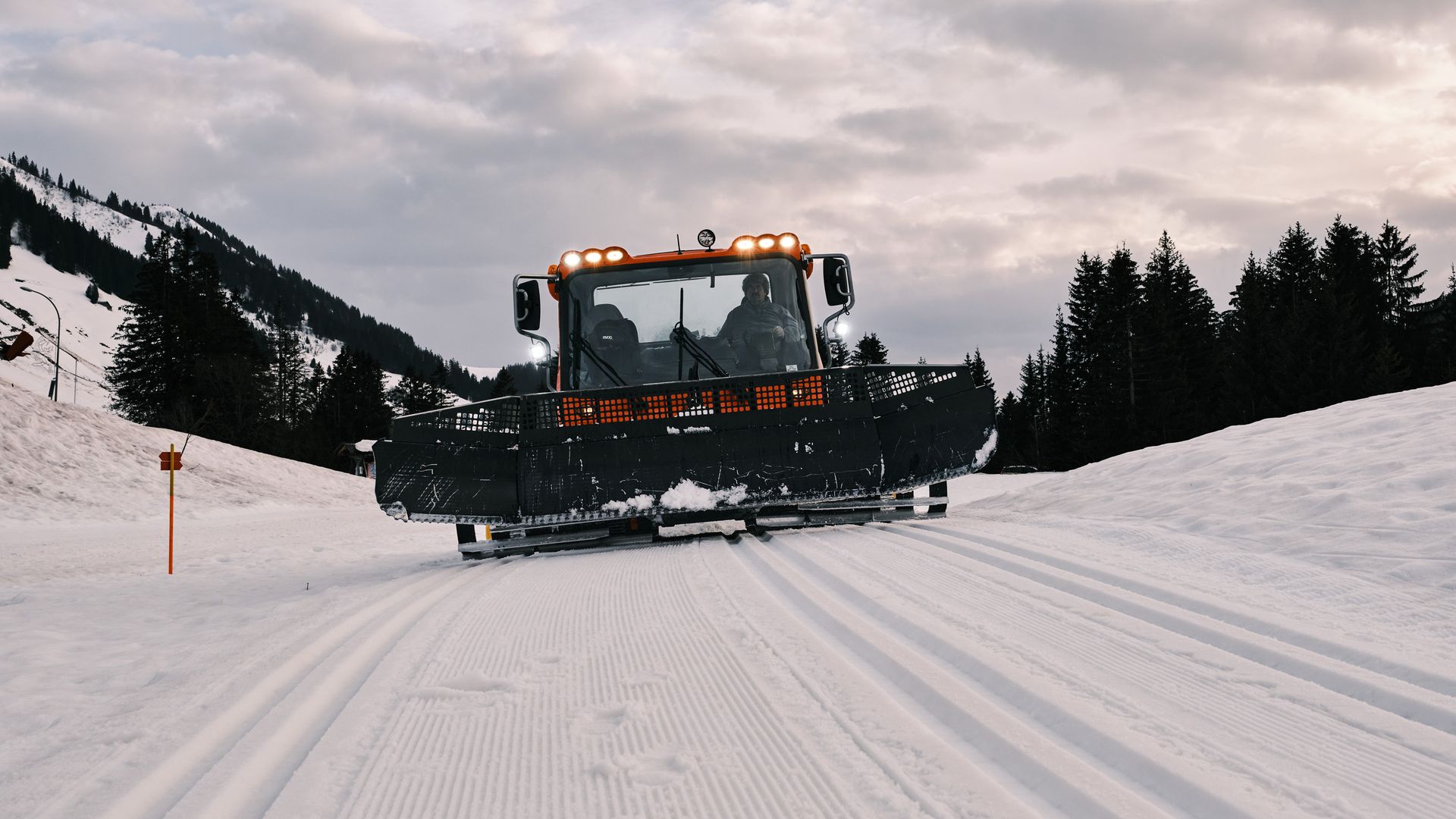 Snow groomer from the front following the cross-country ski tracks