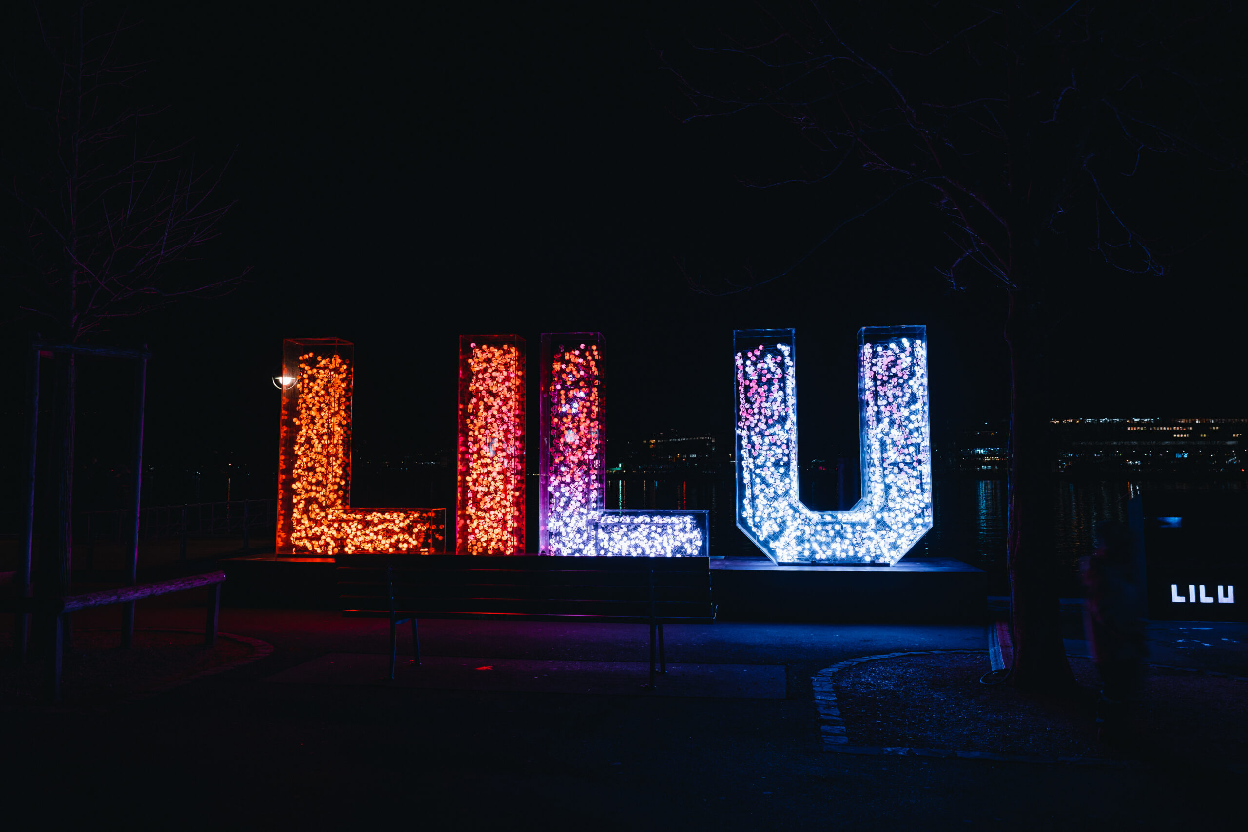 Les lettres L I L U illuminées au bord du lac de Lucerne 