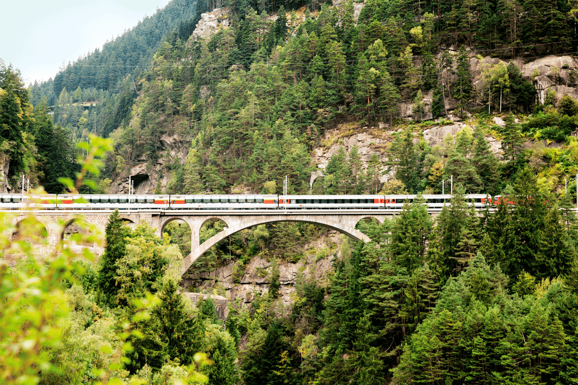 weisser Panoramazug fährt über Brücke