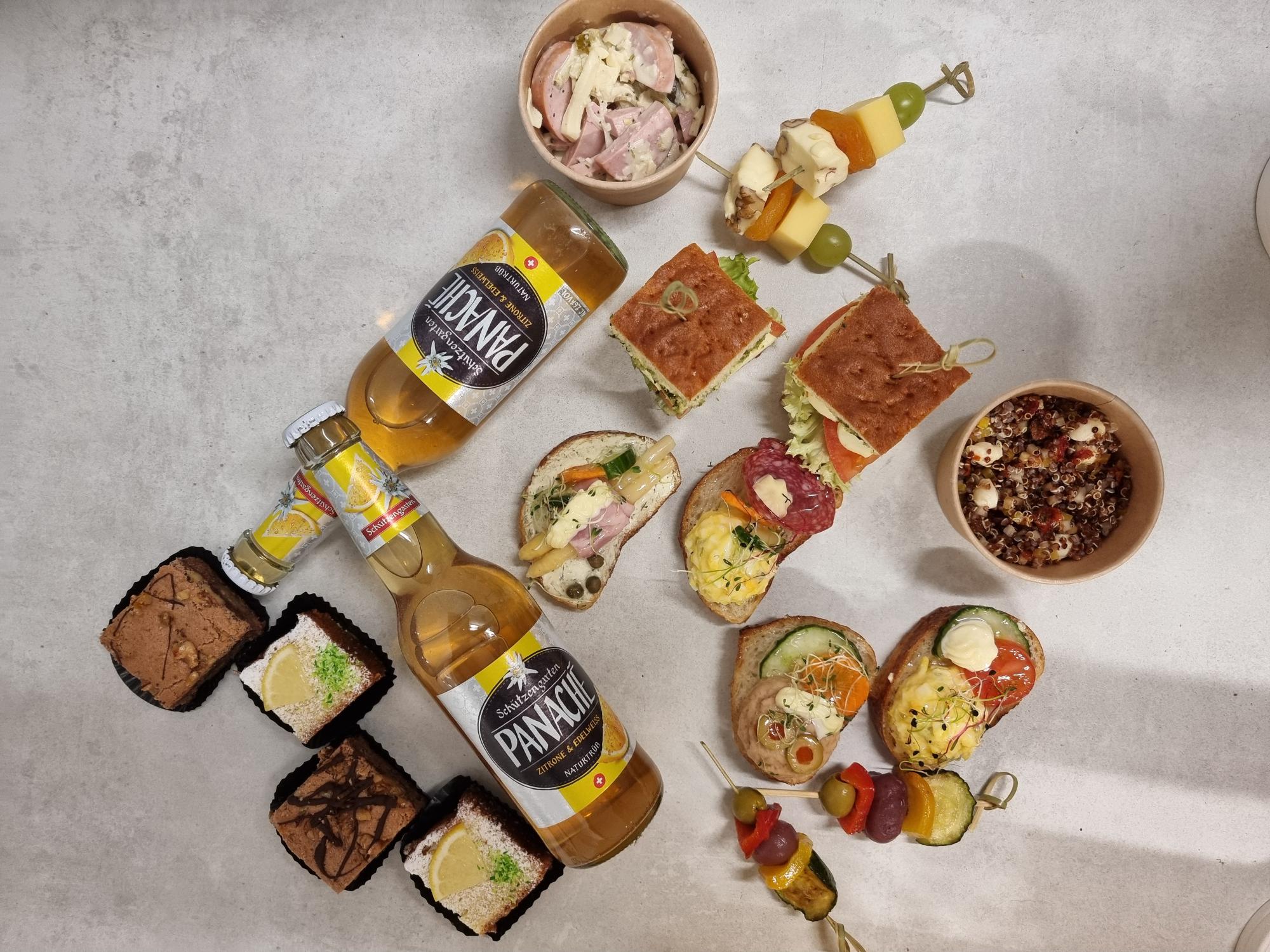 Inhalt Apéro-Picknick-Korb: zwei Salate, zwei Käse-Fruchtspiesse, zwei Gemüsespiesse, sechs verschiedene belegte Brote, vier Desserts und zwei Panachés