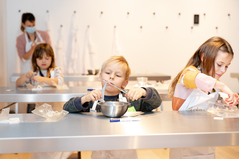 Kinder beim kreativen Schokoladen-Workshop im House of Läderach Atelier während der Factory Tour