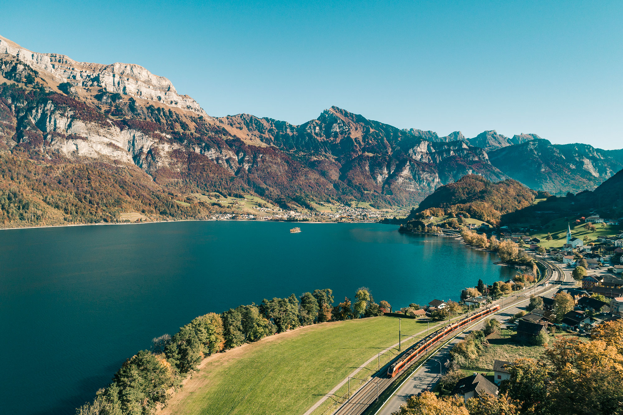 Aare Linth fährt am Walensee entlang, umgeben von Bergen, Seeufer und herbstlicher Landschaft.