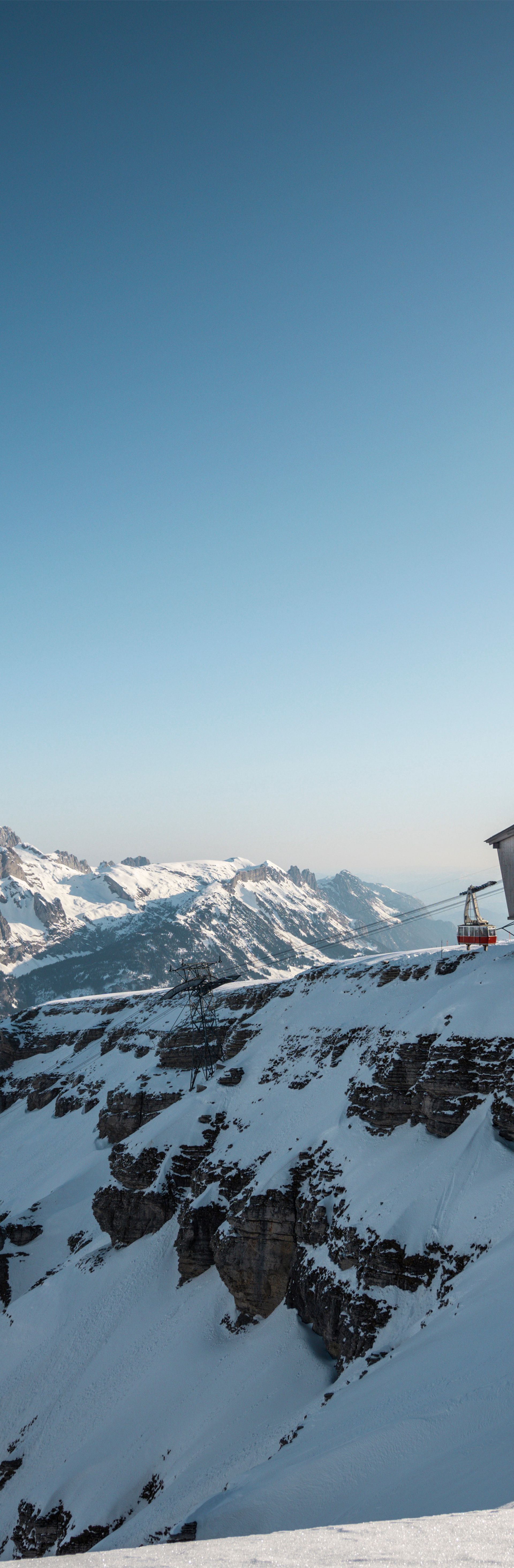 Gipfelgebäude auf dem Chäserrugg im Toggenburg, umgeben von verschneiten Alpen unter klarem, blauem Himmel