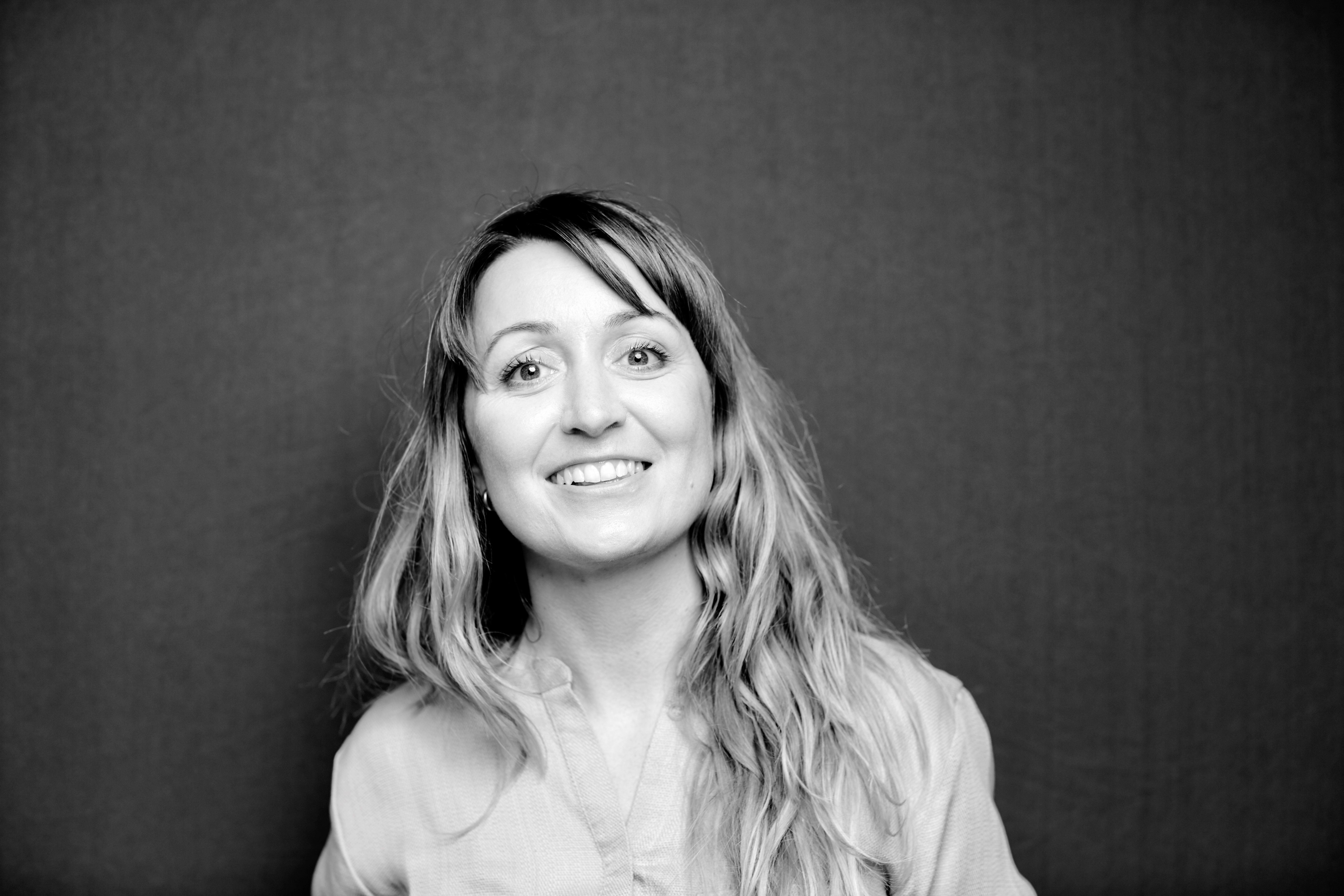 Black-and-white portrait of Swiss artist Corinne Weidmann against a dark background.