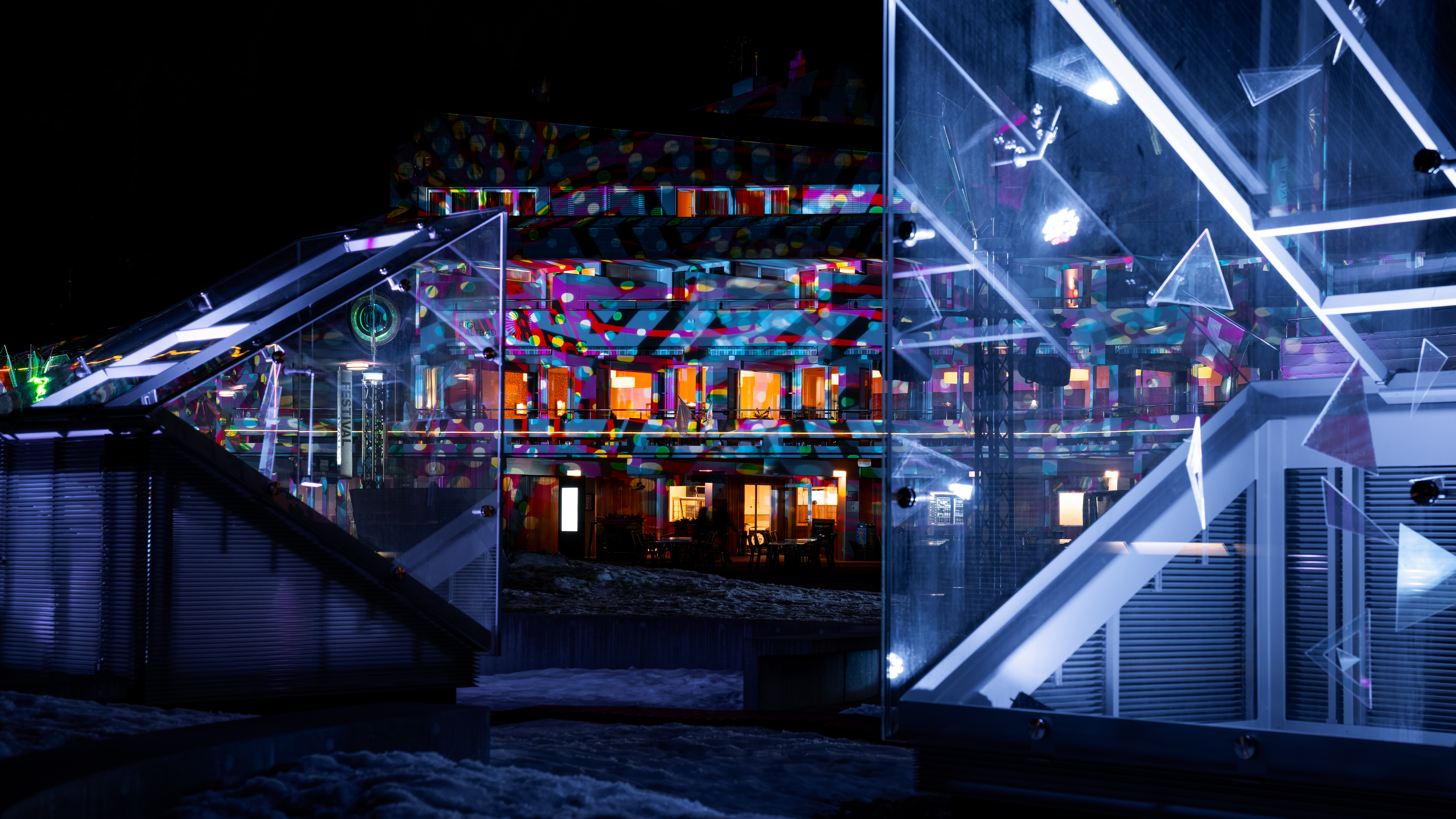 Farbenfrohe Lichtinstallationen und leuchtende geometrische Elemente inszenieren ein Gebäude auf der Rigi und schaffen eine eindrucksvolle Atmosphäre während des Rigi Lichtfestivals.