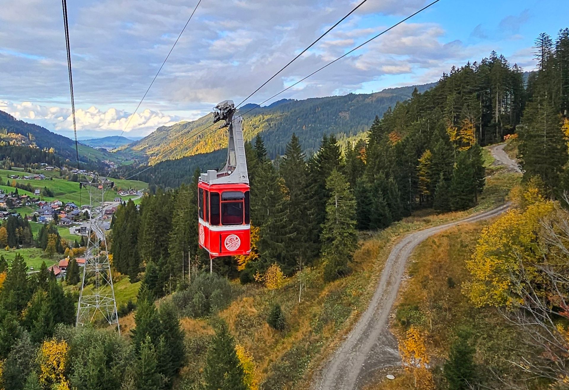 Eine rote Gondel vor einem herbstfarbenen Hintergrund