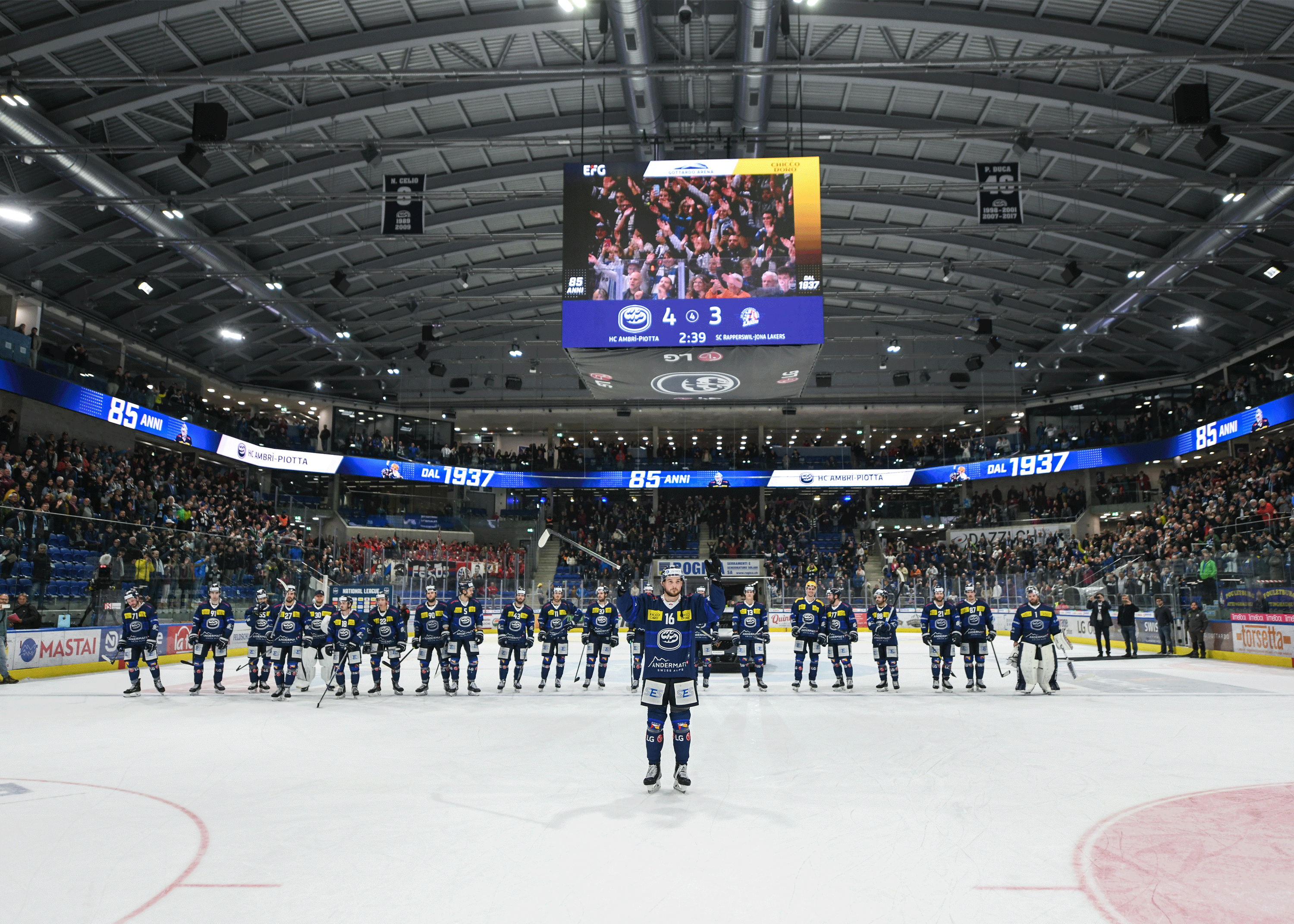 The ice hockey team HC Ambrì-Piotta stands on the ice of the Gottardo Arena after a home victory, celebrating its 85th anniversary together with the fans.