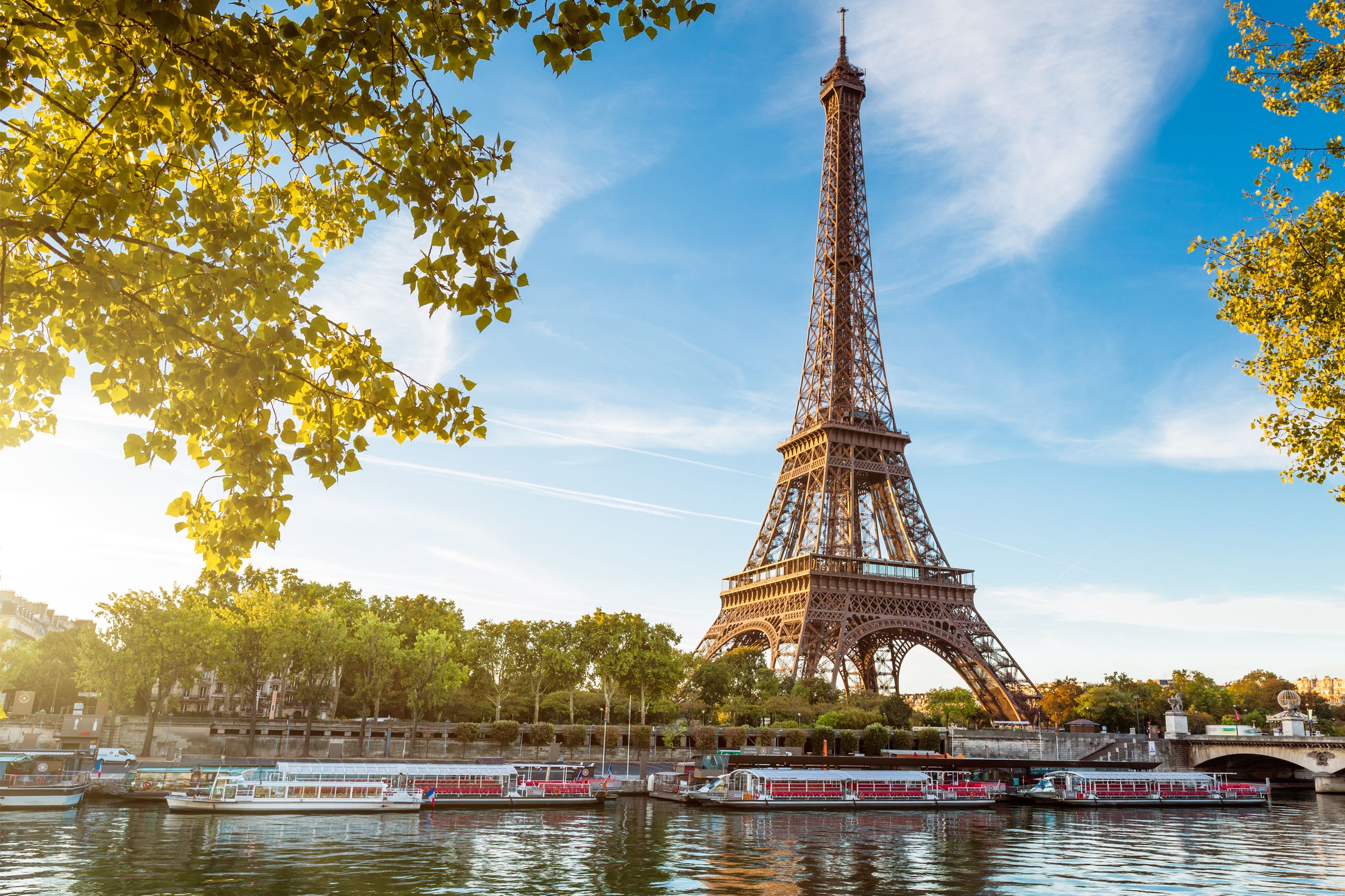 Eiffelturm vor einer Brücke die über den Fluss führt