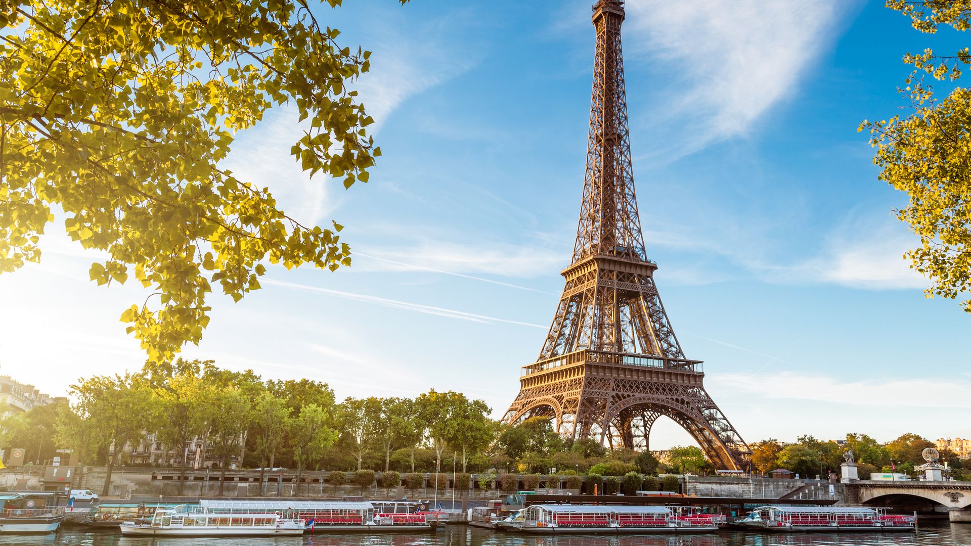 Eiffelturm vor einer Brücke die über den Fluss führt