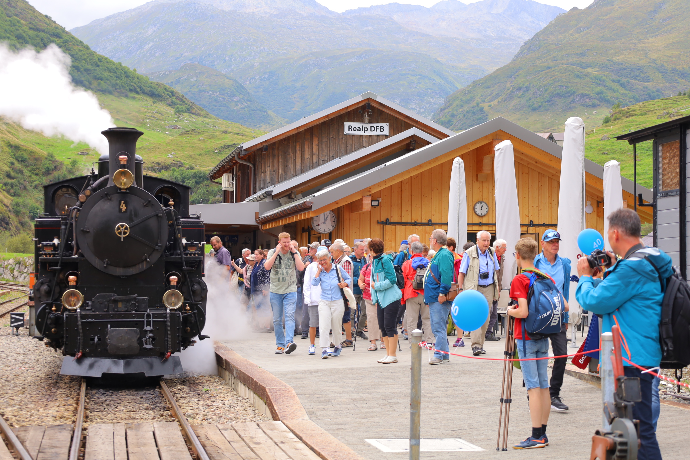 Group of visitors at the Furka Steam Railway in Realp with historic steam locomotives