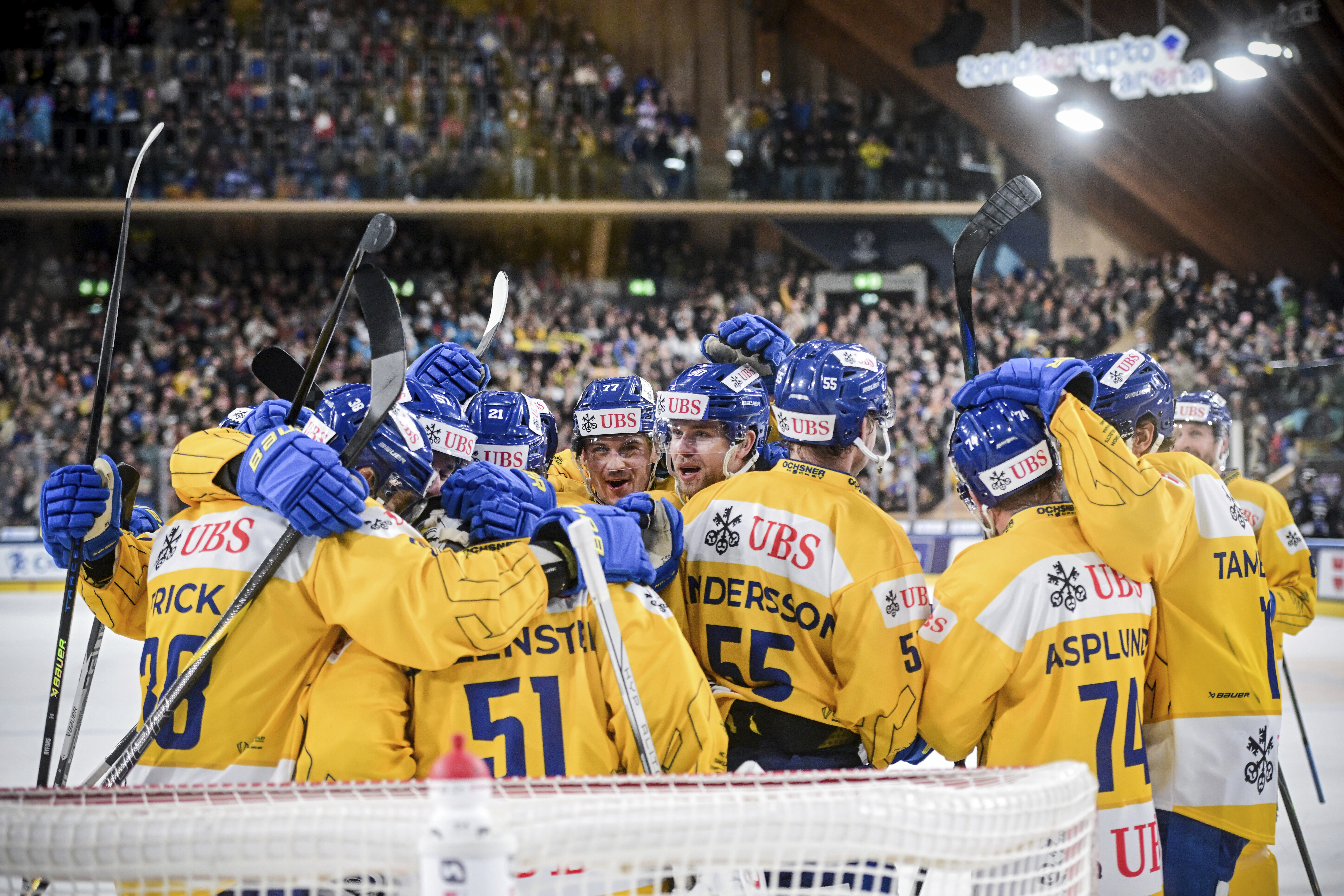 Das Hockeyteam vom HC Davos steht vor dem Tor und jubelt über das Goal. 