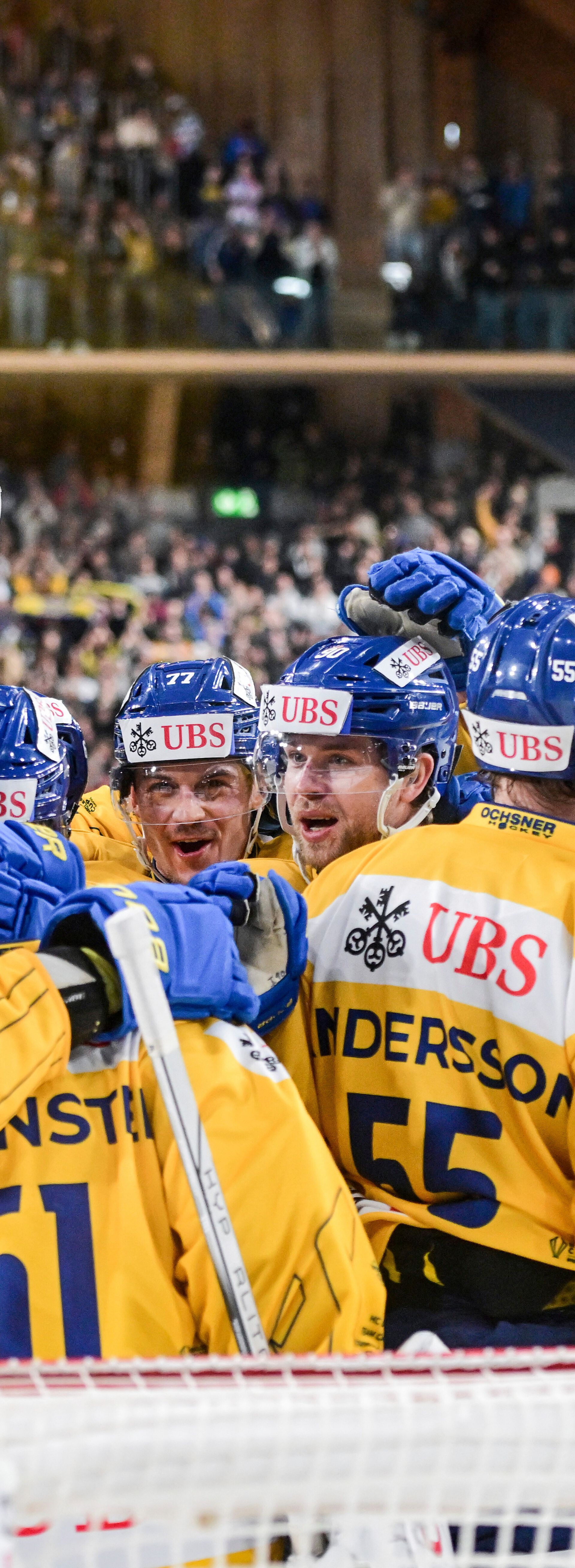 Das Hockeyteam vom HC Davos steht vor dem Tor und jubelt über das Goal.