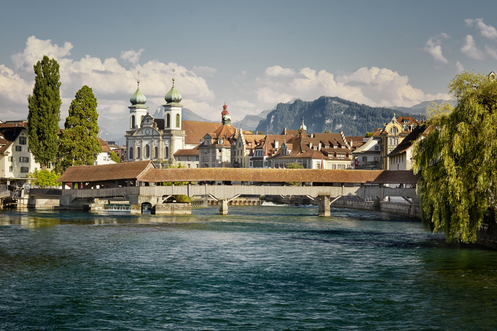 The Spreuer Bridge and Jesuit Church in Lucerne with the old town and the Alps in the background.