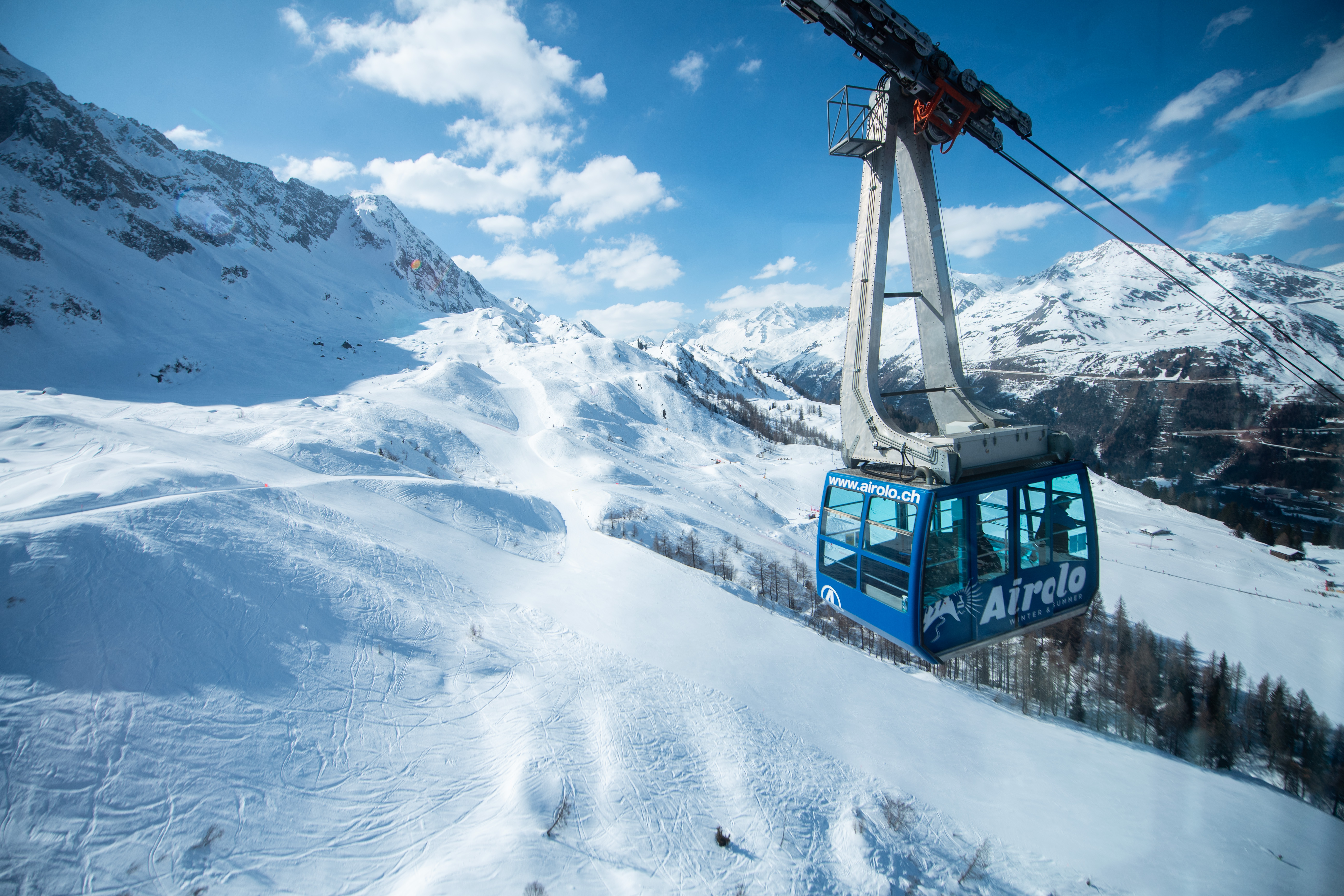 Blaue Schwebebahn im sonnigen Skigebiet Airolo Pesciüm