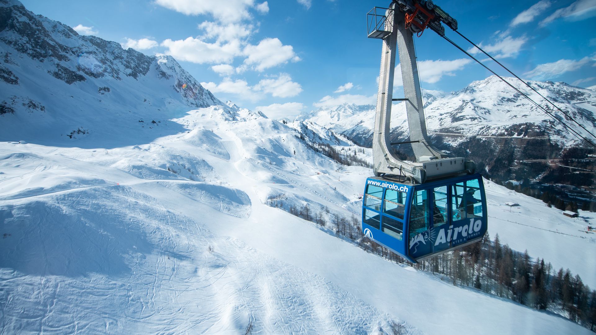 Blaue Schwebebahn im sonnigen Skigebiet Airolo Pesciüm