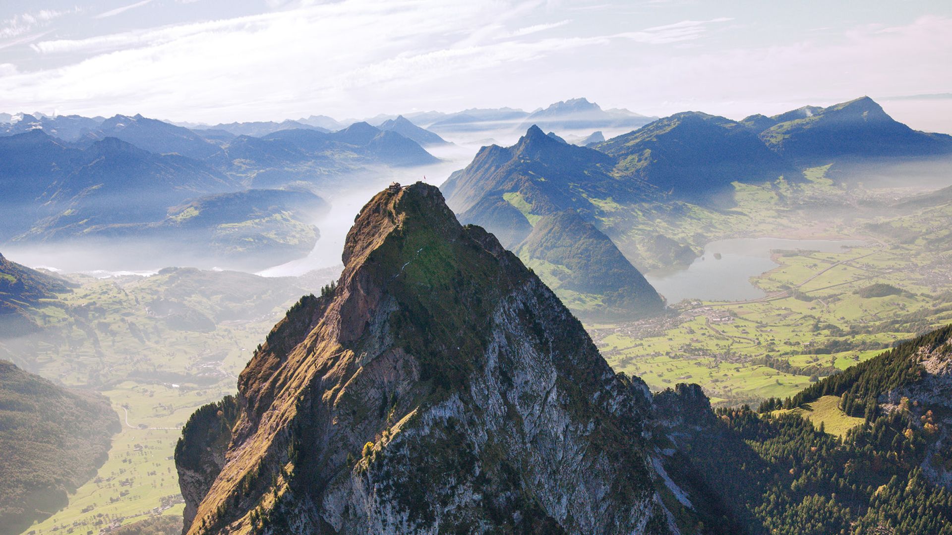 Aussicht über Bergpanorama mit leichtem Nebel und grünen Tälern