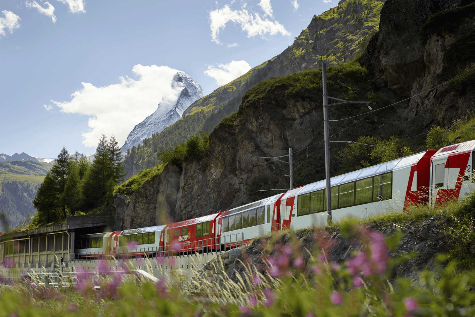 rot weisser Zug fährt vor dem Matterhorn durch