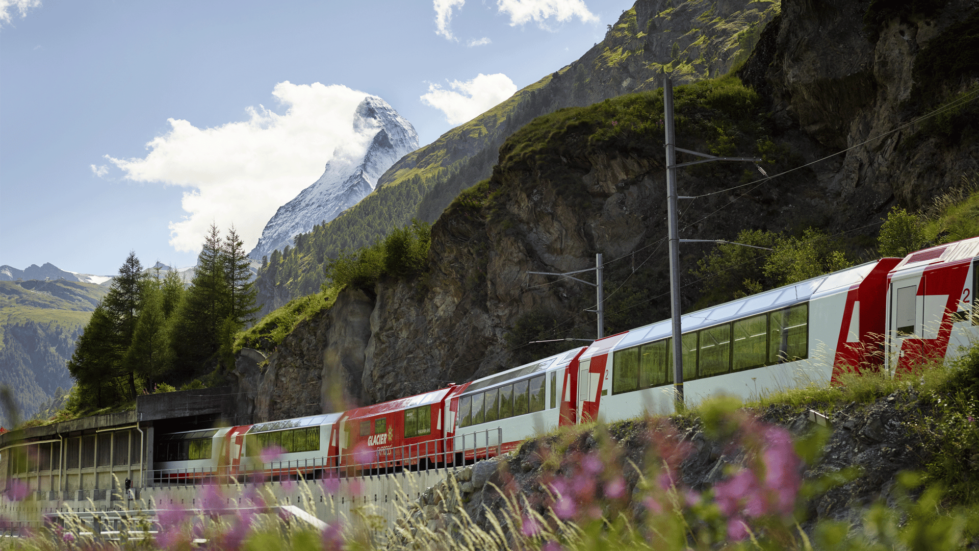 rot weisser Zug fährt vor dem Matterhorn durch