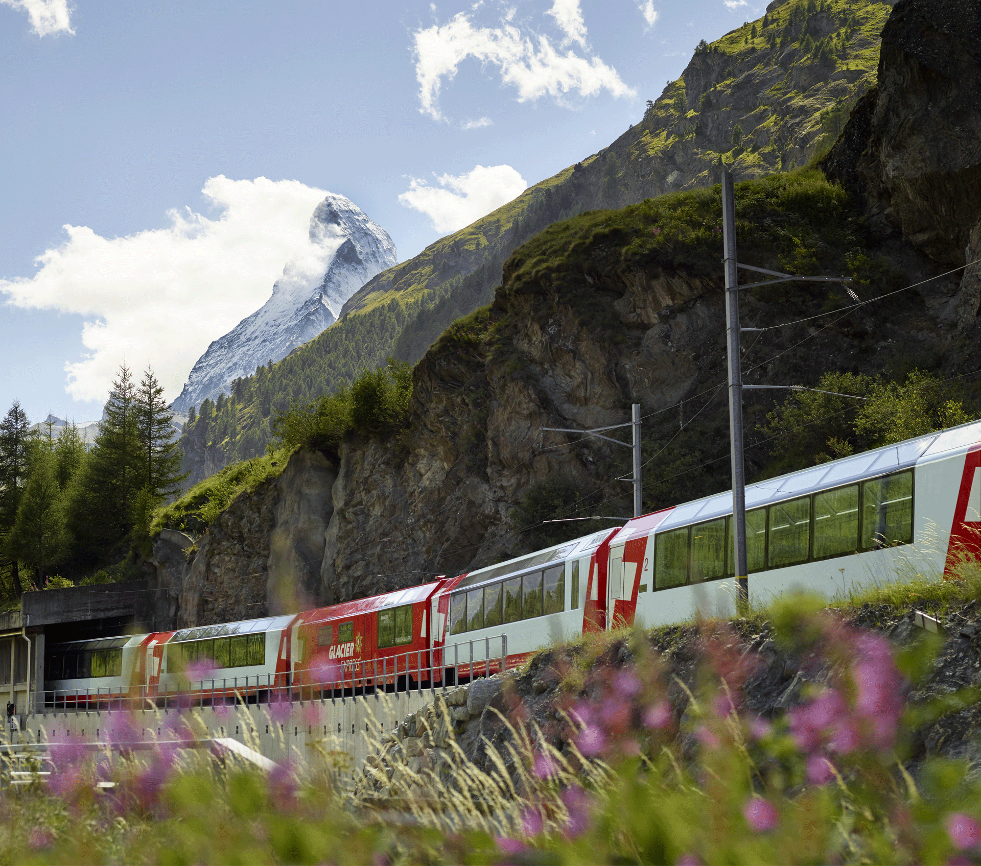 rot weisser Zug fährt vor dem Matterhorn durch