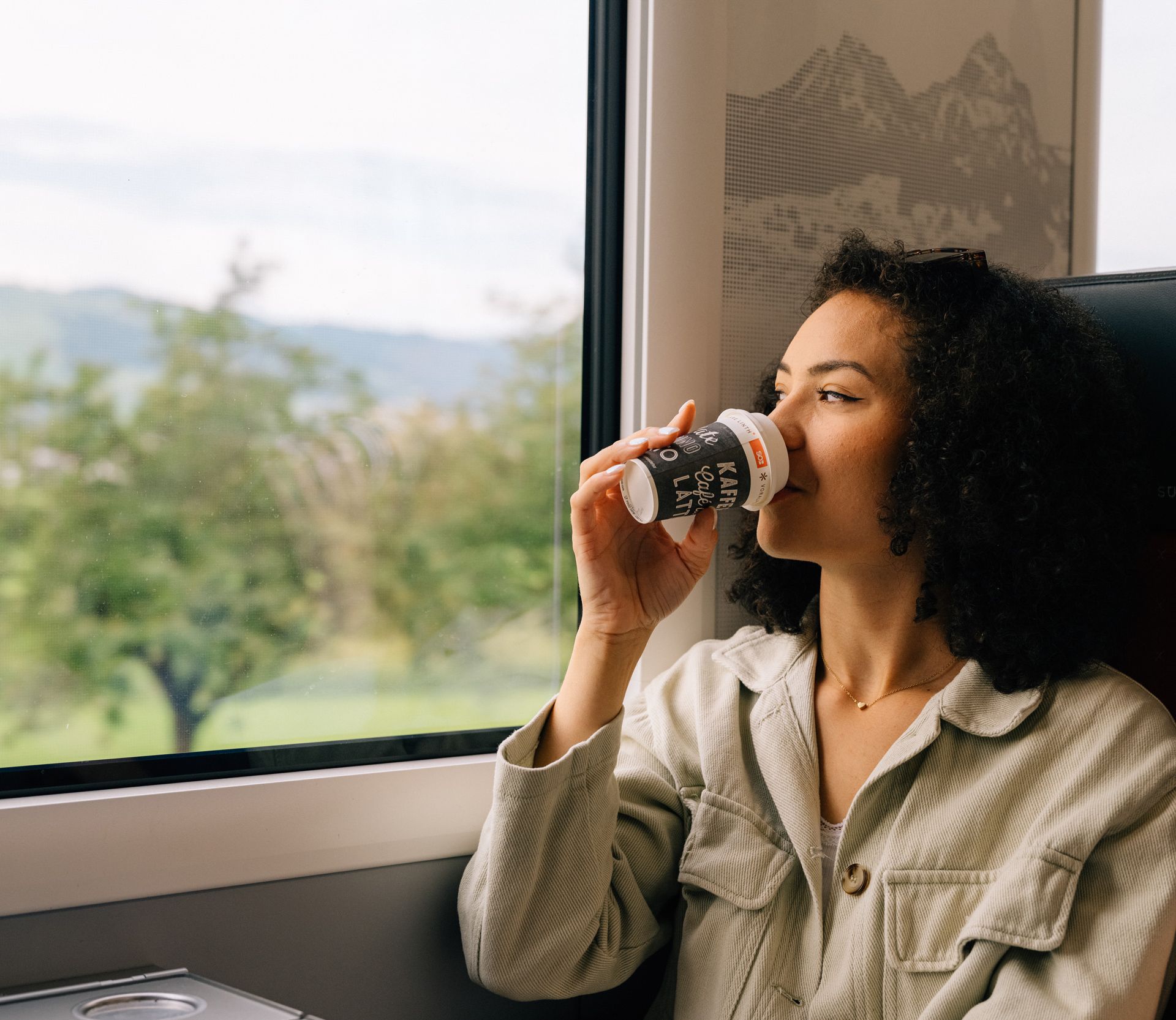 Une jeune femme savoure un café au bistrot du train de la Südostbahn