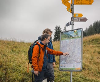 Zwei Männer studieren eine Wanderkarte in den Bergen