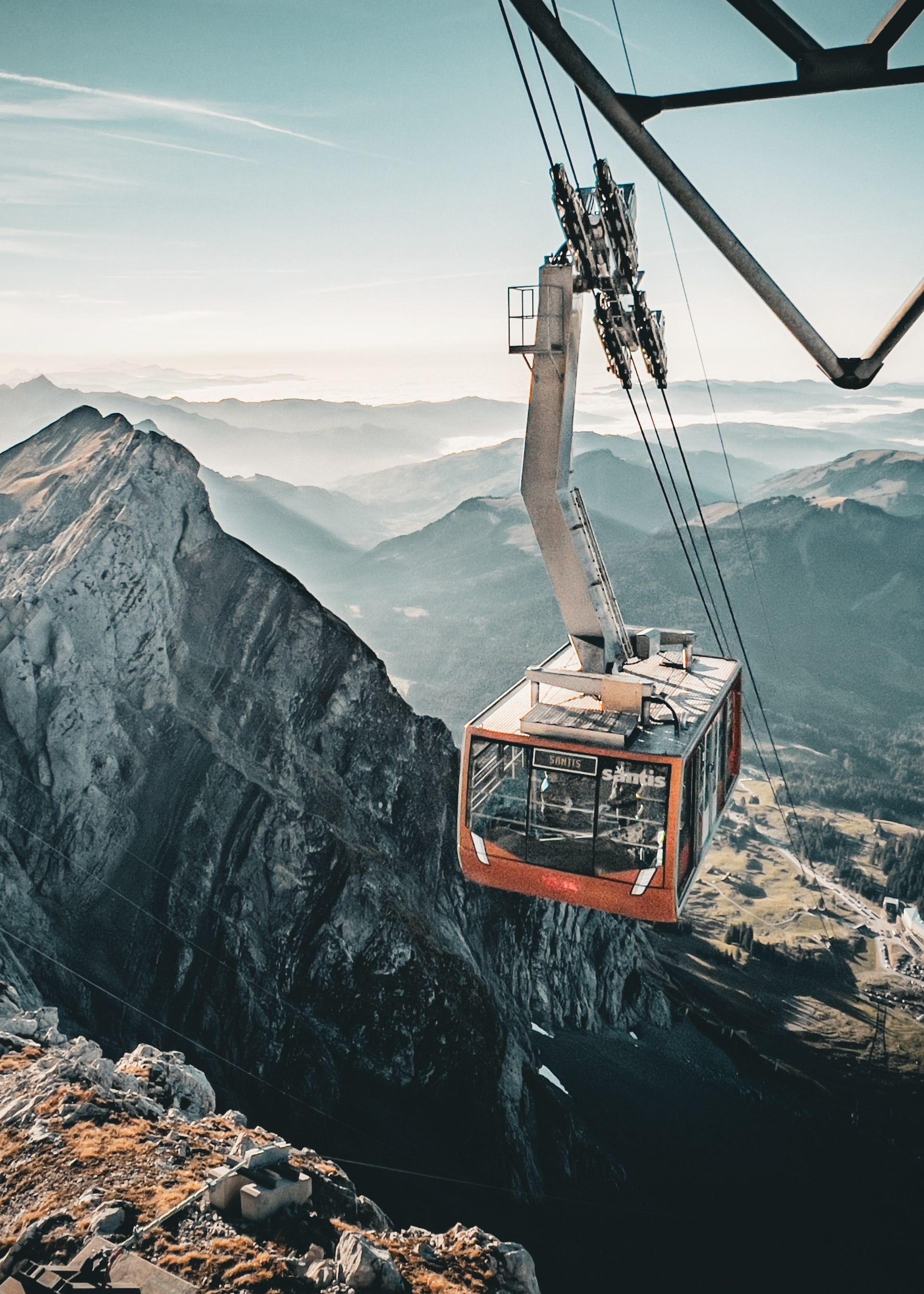 Die Säntis-Schwebebahn fährt über felsige Gipfel mit Blick auf das Alpenpanorama und das Nebelmeer.