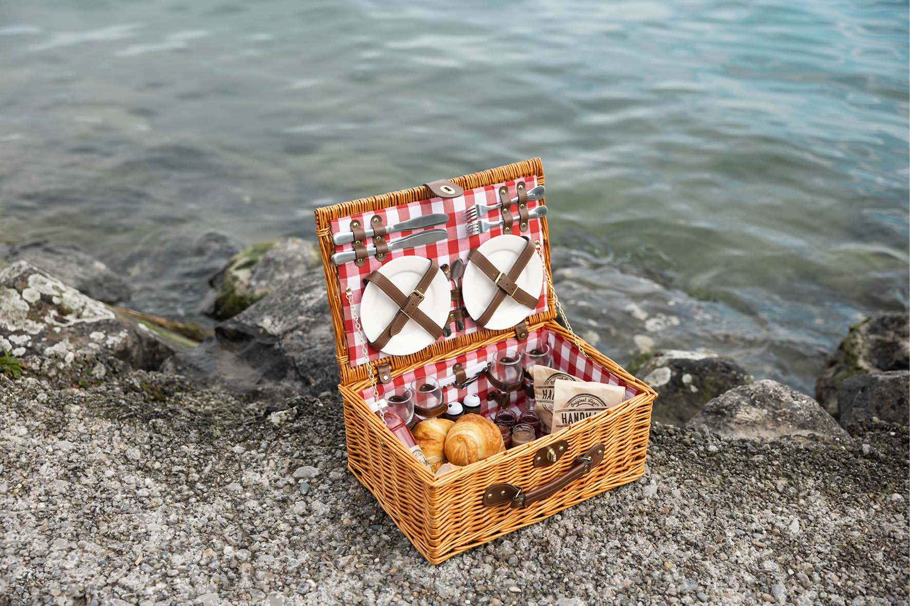 Cestino della colazione aperto sulle rive del Lago di Costanza. Si vedono due croissant. 
