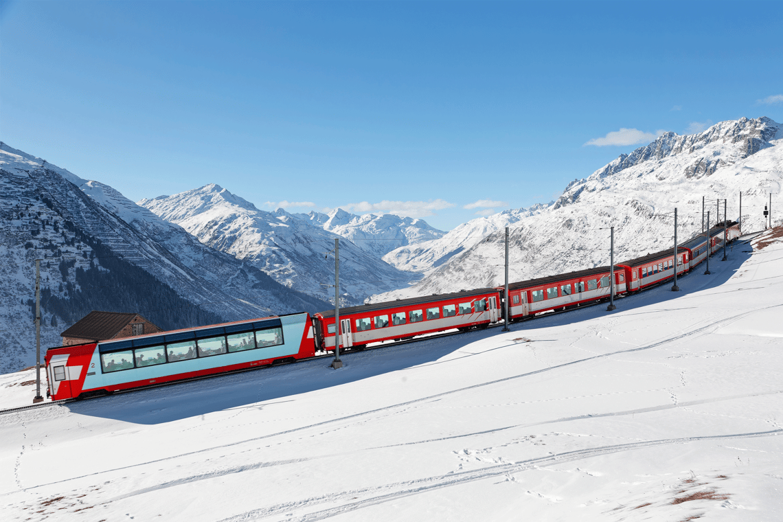 Glacier Express Oberalppass rot weisser Zug fährt durch schneebedeckte Berglandschaft