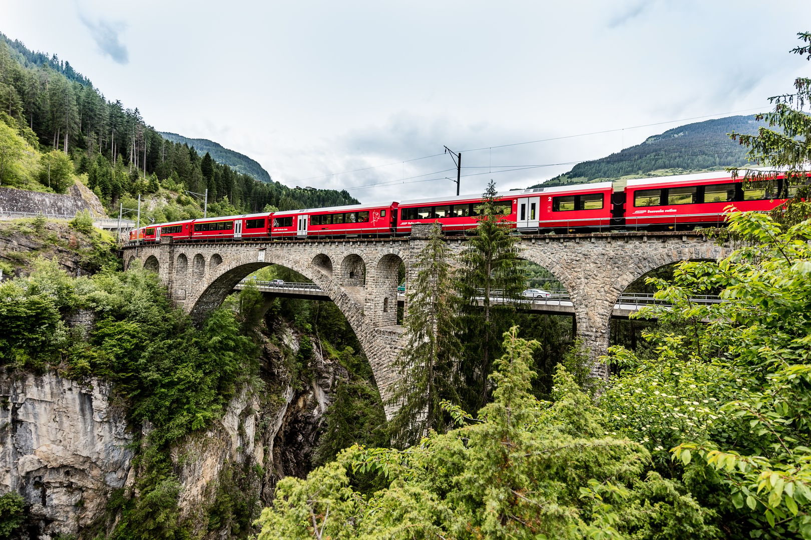 Roter Zug fährt über Viadukt