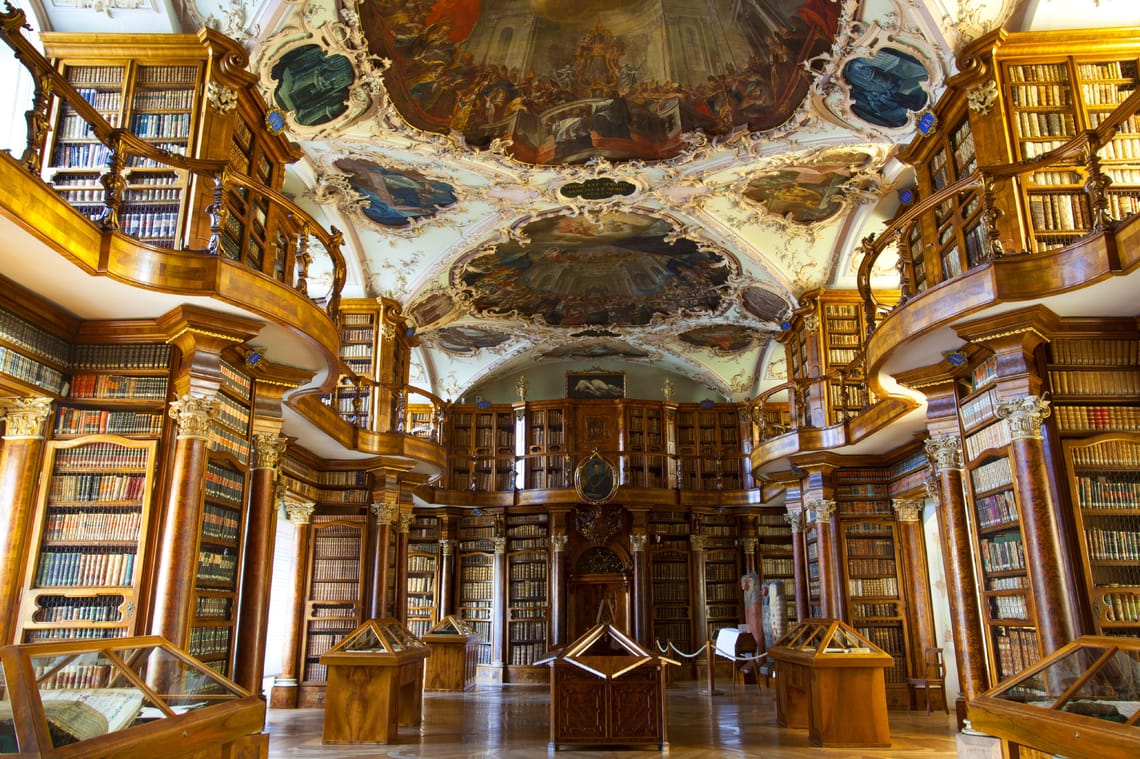 Antica biblioteca con disegni sul soffitto e scaffali in legno