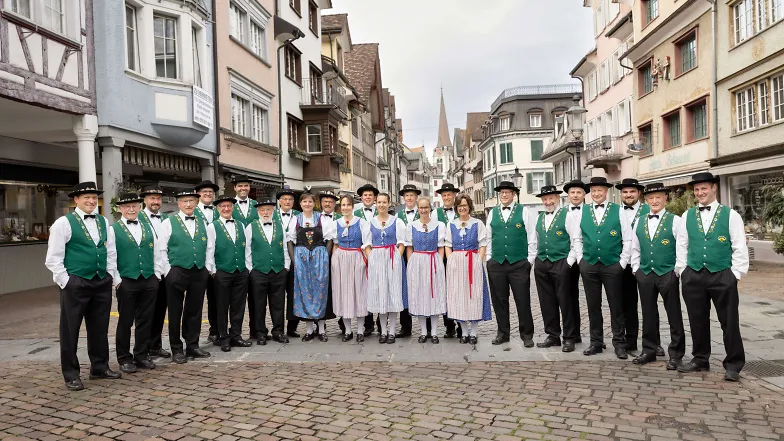 Eine Jodelgruppe gekleidet in grün und blau