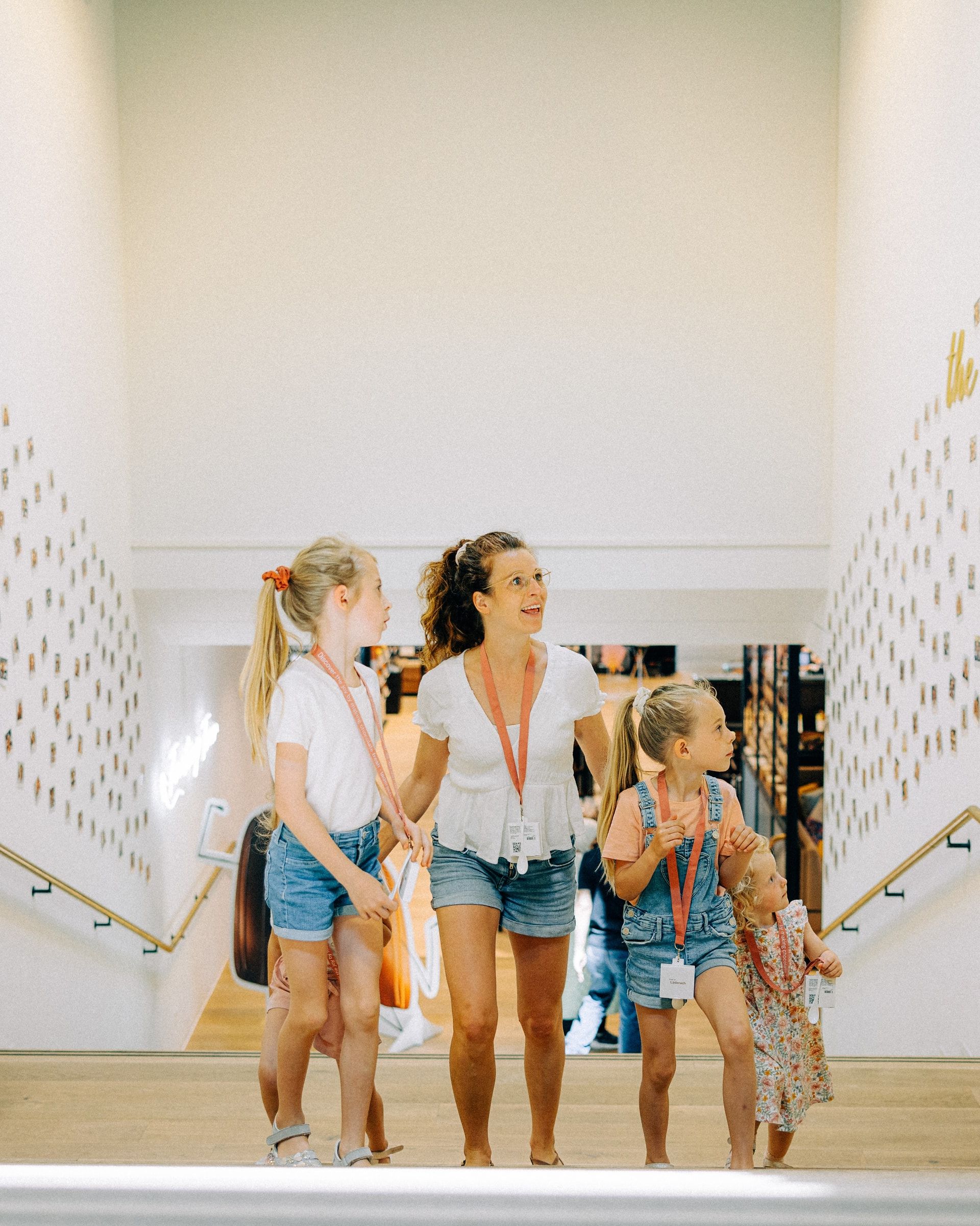 Mutter mit drei Kindern läuft Treppe in Museum hoch