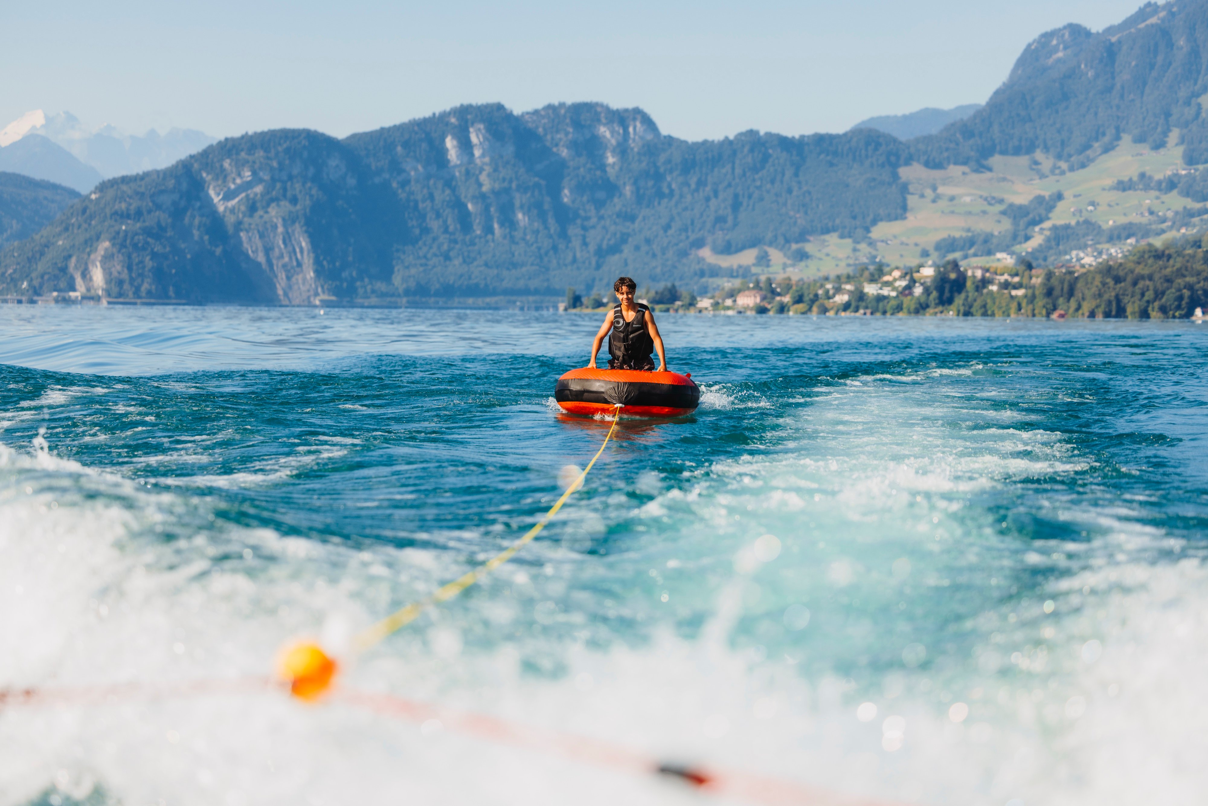 Guest enjoying a towable tube ride during a private boat tour on Lake Lucerne.