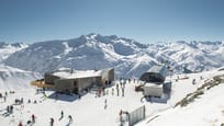 Luftaufnahme der Bergstation Gütsch mit der Gondelbahn Gütsch-Express, den mehrfach ausgezeichneten Restaurants und diversen Wintersportlerinnen und -sportler