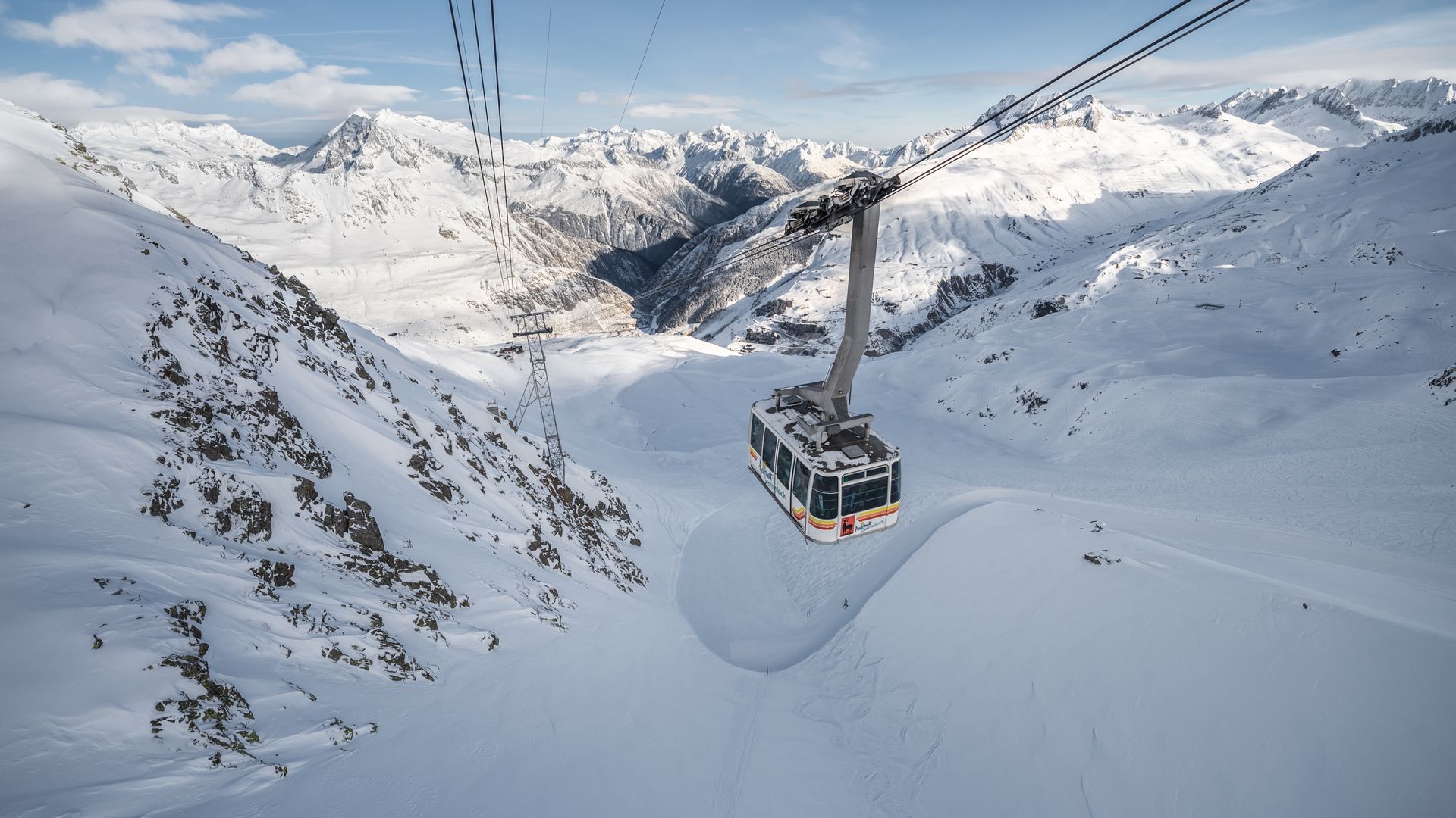 Gemsstock-Gondel zwischen Gurschen und Bergstation vor winterlichem Bergpanorama