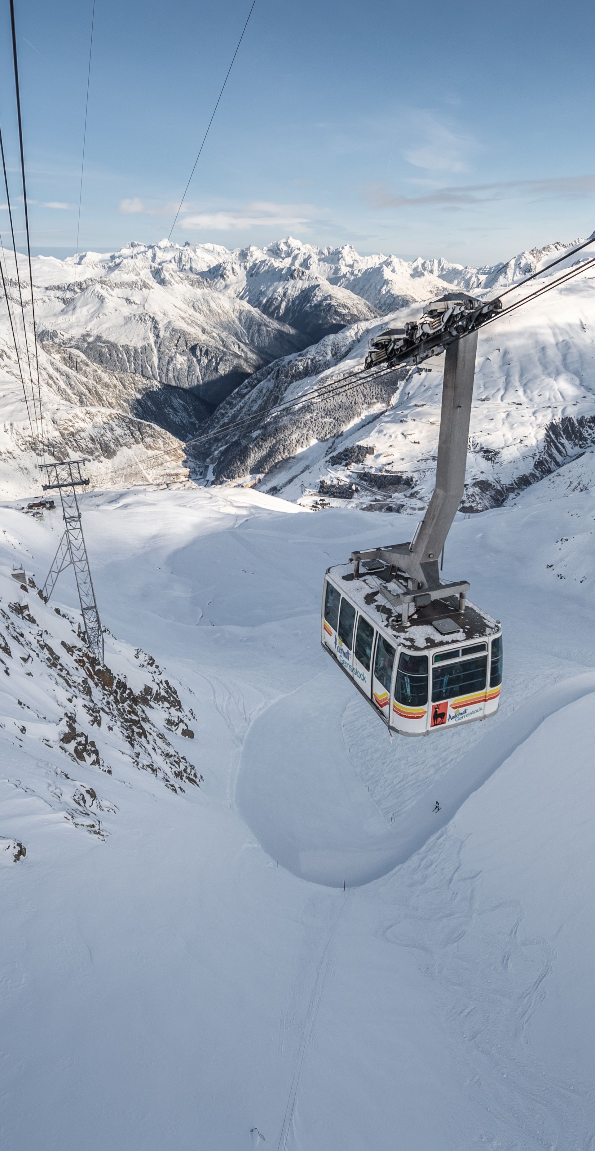 Gemsstock-Gondel zwischen Gurschen und Bergstation vor winterlichem Bergpanorama