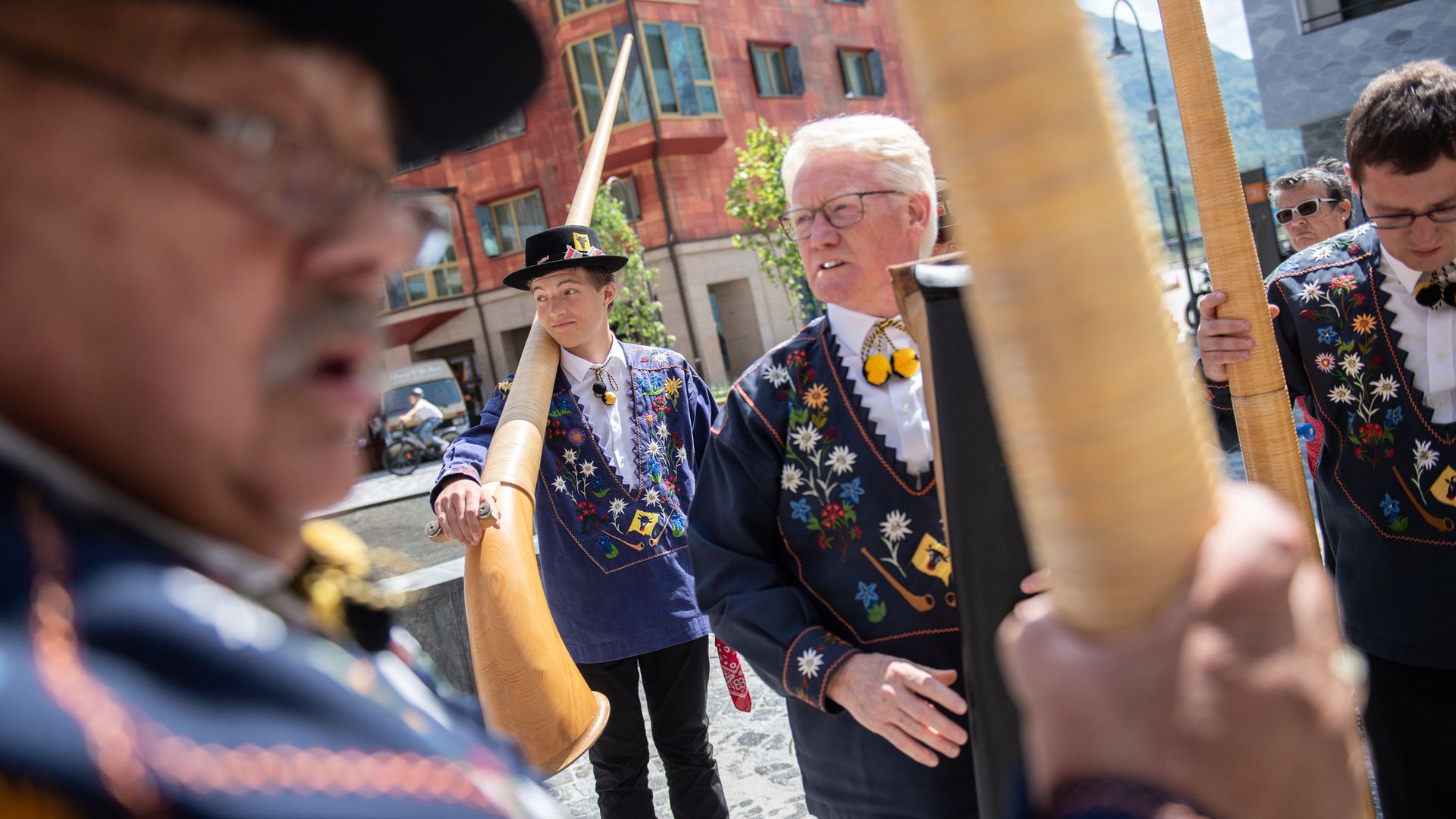 Alphornbläser in der traditionellen Urner Tracht tragen ihre Instrumente auf die Piazza Gottardo