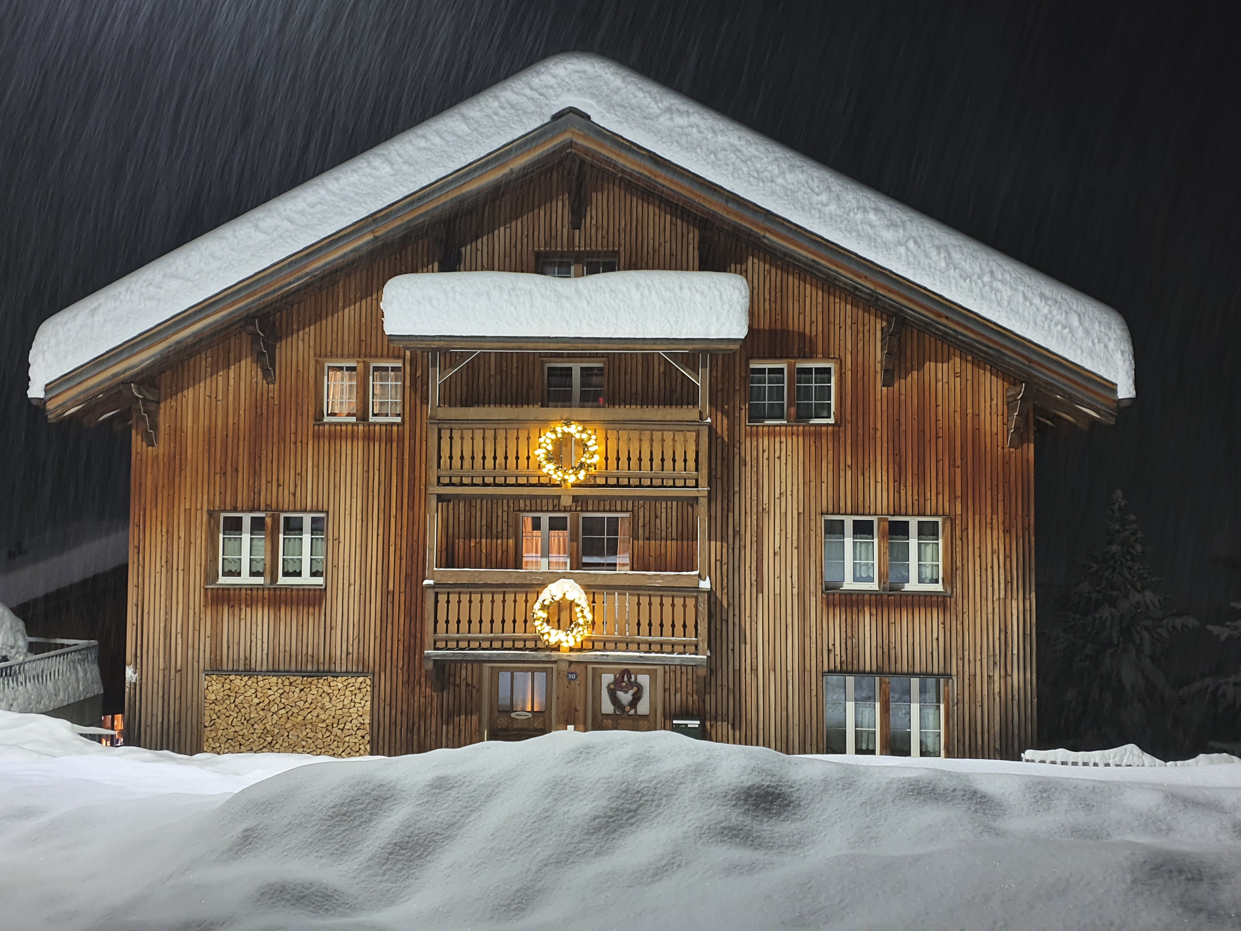 Auf dem Bild ist das Schneebedeckte Chrämerhus in der Nacht zu sehen.