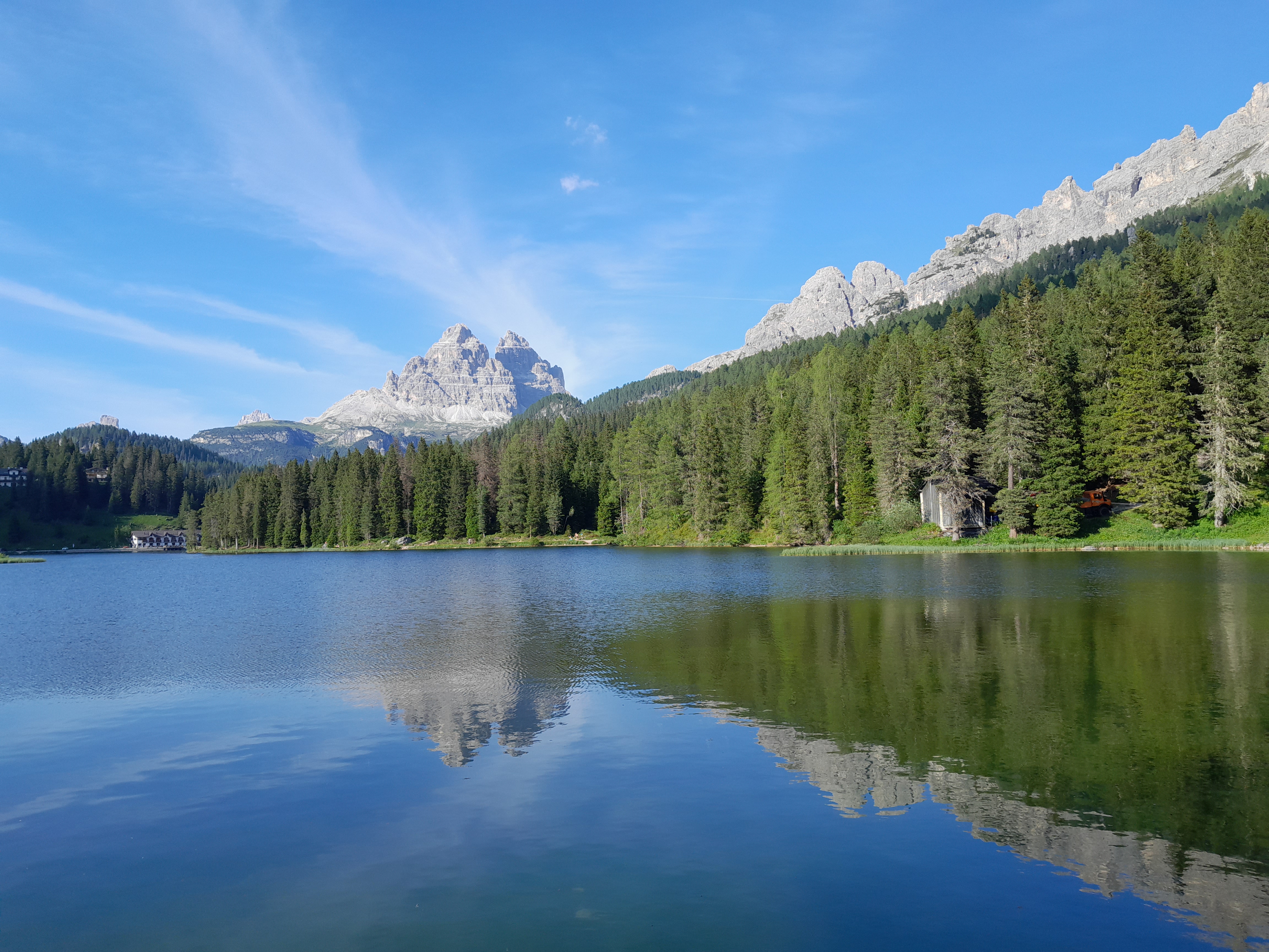 See mit Wald und Bergen im Hintergund