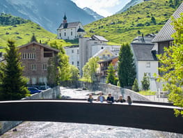mys-Visite guidate nei villaggi dell'Urserntal-Dorfführung auf Brücke mit Kapelle im Hintergrund Visite guidate nei villaggi dell'Urserntal