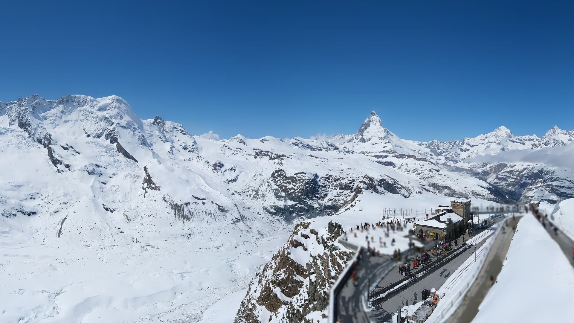 Panoramic view of the Gornergrat via webcam in May, with the Matterhorn in the background and a clear blue sky.